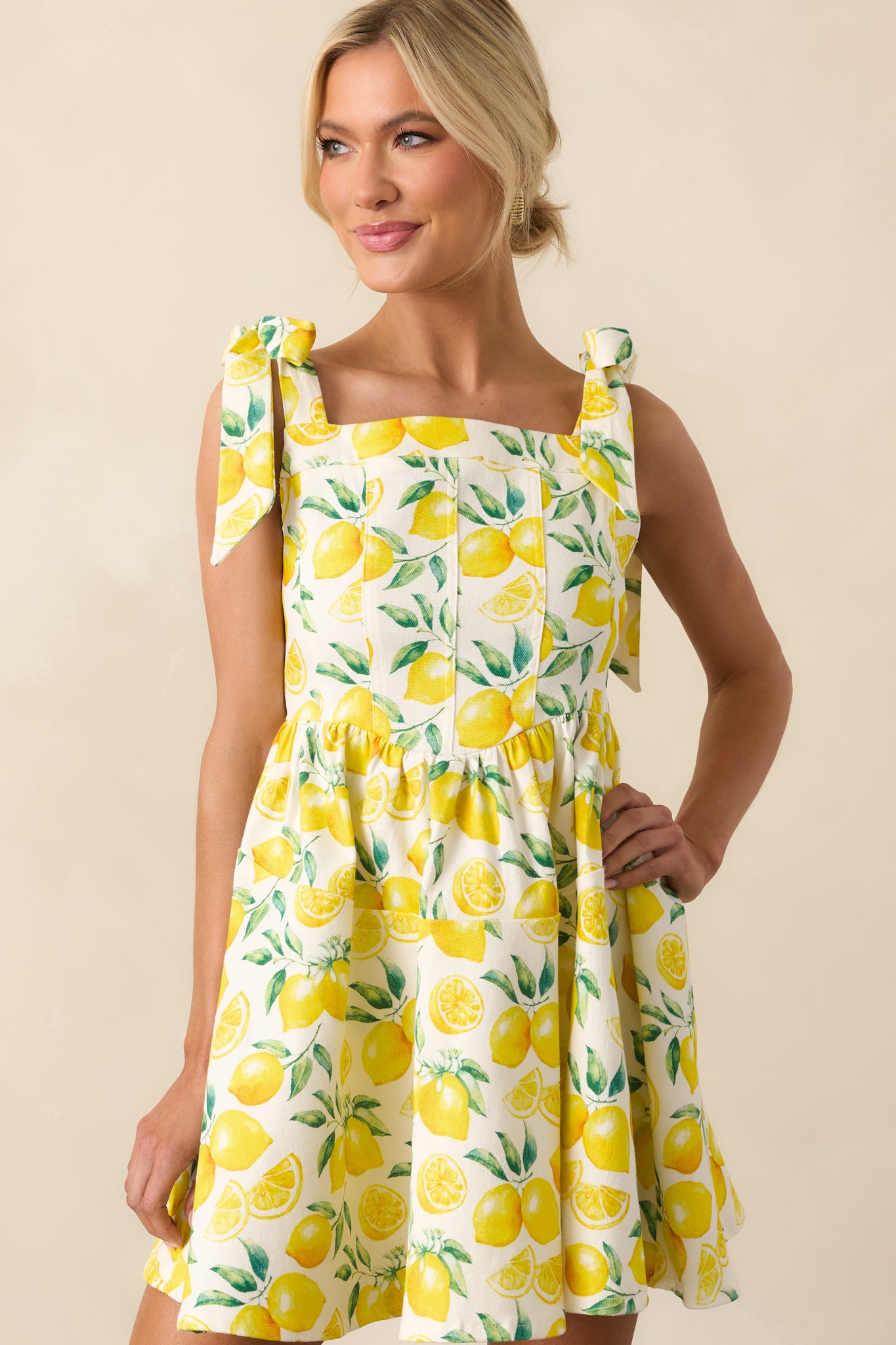 Detailed view of the lemon print fabric and stitching across the lower portion of the mini dress.