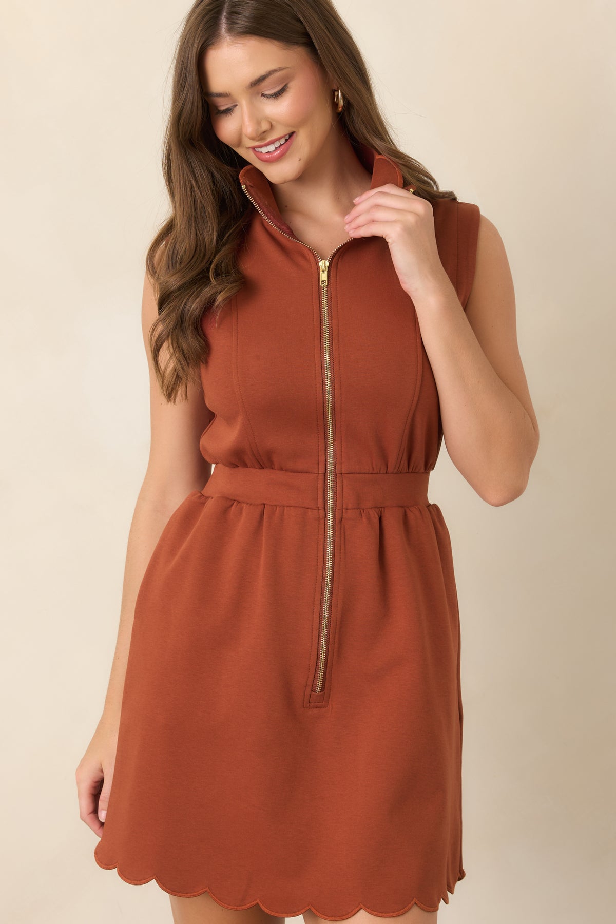 Mini dress showcasing the polished gold front zipper against its sleek, structured silhouette.