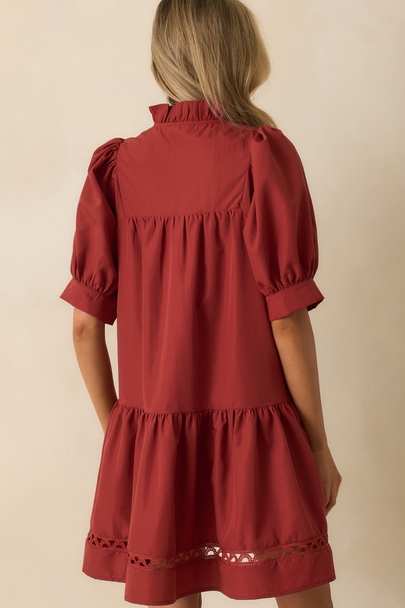 Rear view of the mini dress showing tiered hem and ladder lace detailing along the back.
