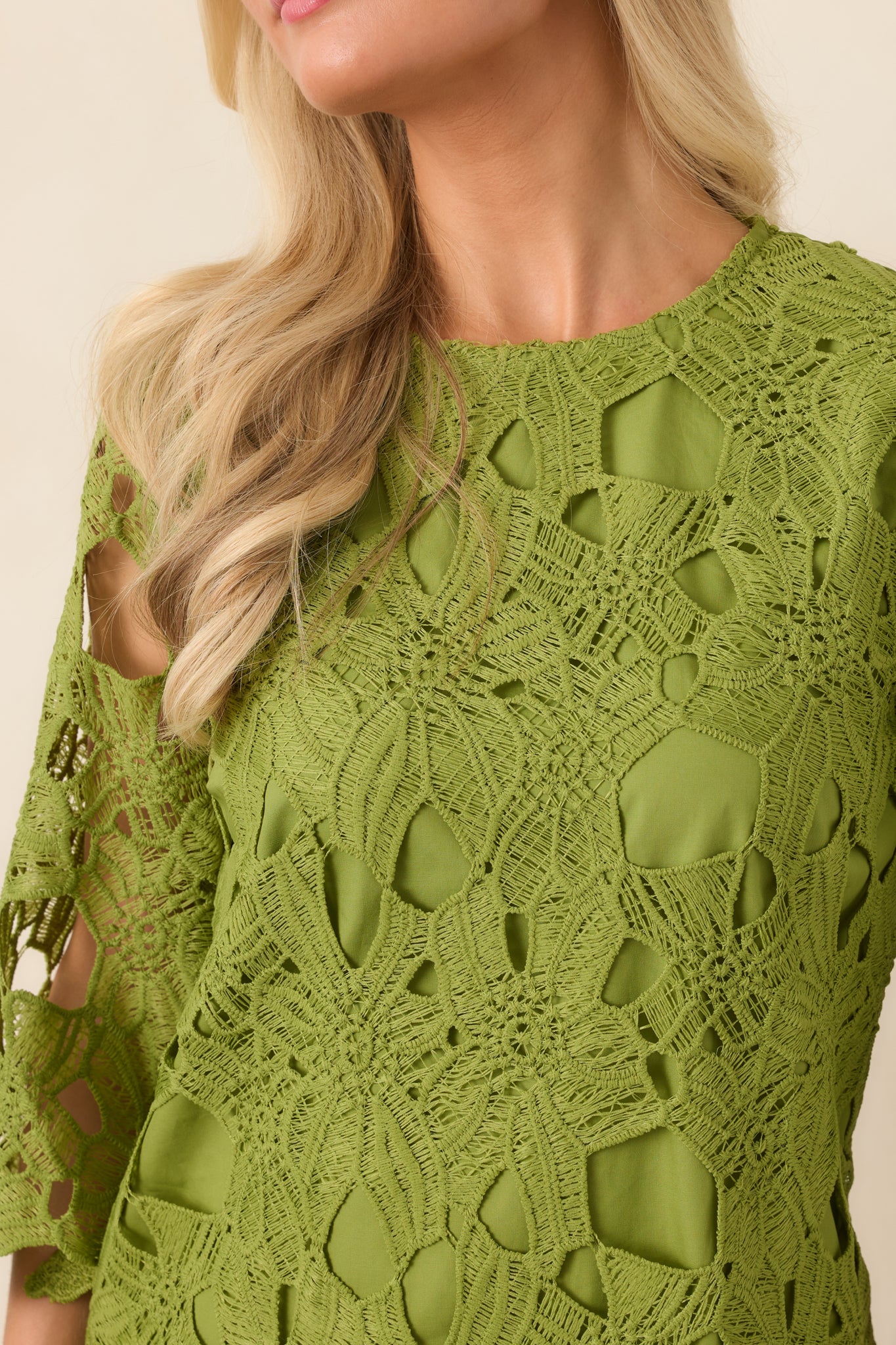 Close-up of the mini dress highlighting the sheer sleeve texture, round neckline, and softly tailored fabric construction.