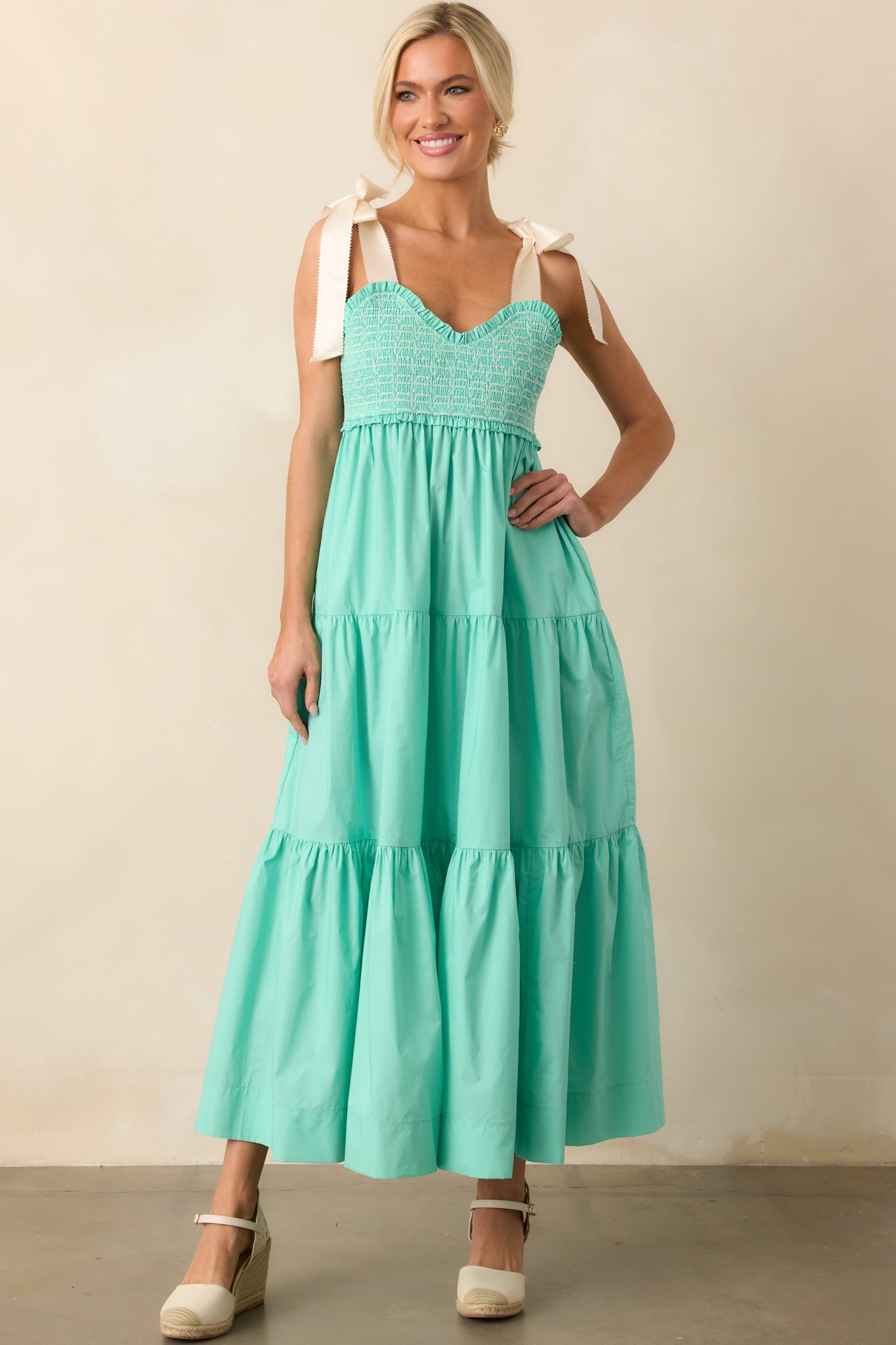 A romantic midi dress in mint green, featuring a sweetheart neckline and dainty ivory bow straps for a whimsical touch.