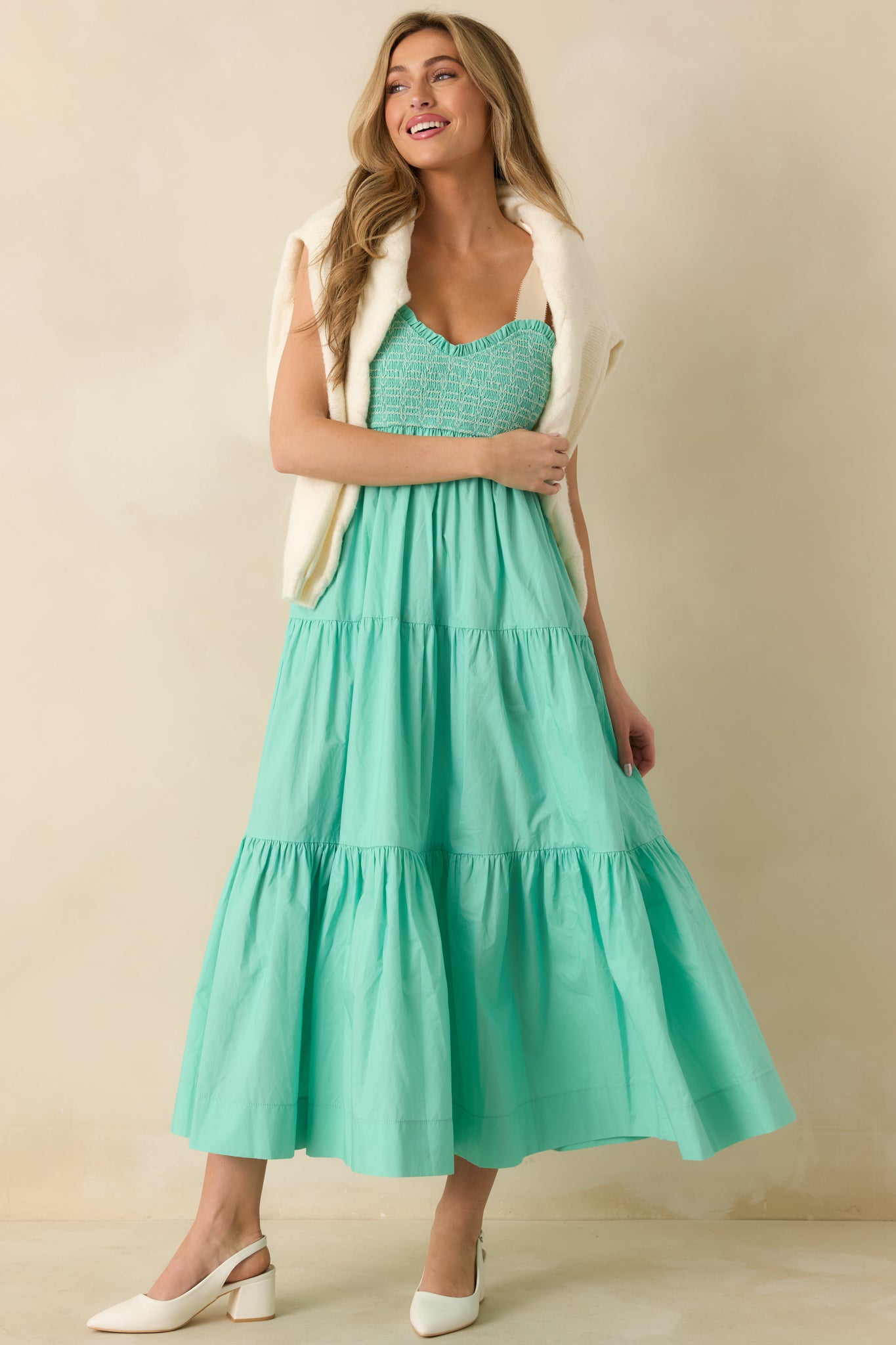Mint green midi dress with embroidered smocked bust, sweetheart neckline, and gathered skirt with side pockets.