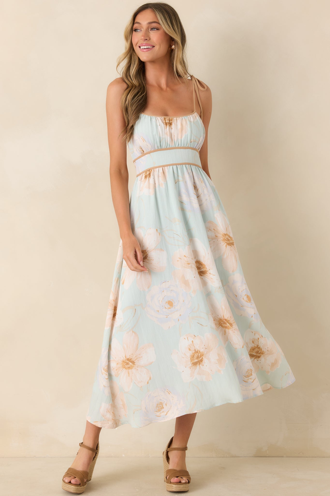 Mint green dress featuring watercolor-inspired floral blooms, adjustable tie straps, a softly structured bodice, and a flowing skirt.