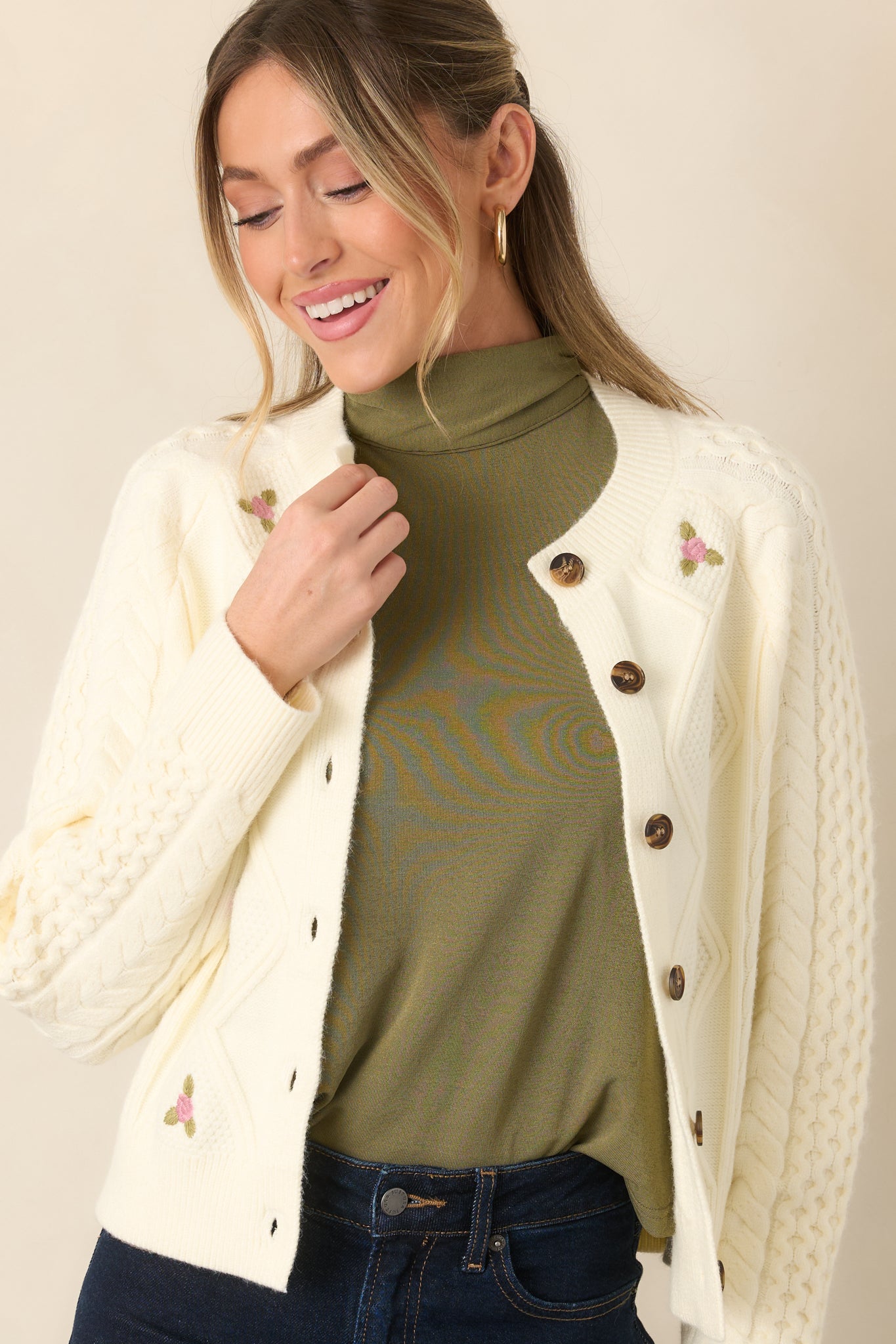 Mixed knit textures create dimension across this cardigan, accented by delicate pink embroidered flowers and ribbed edging.