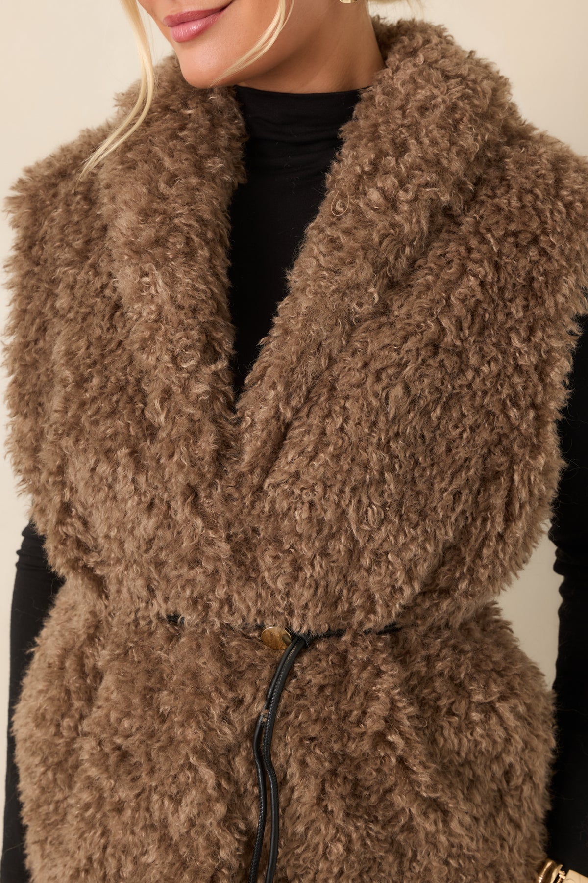 Close-up of the curly mocha faux fur, oversized shawl collar, and faux leather drawcord belt.