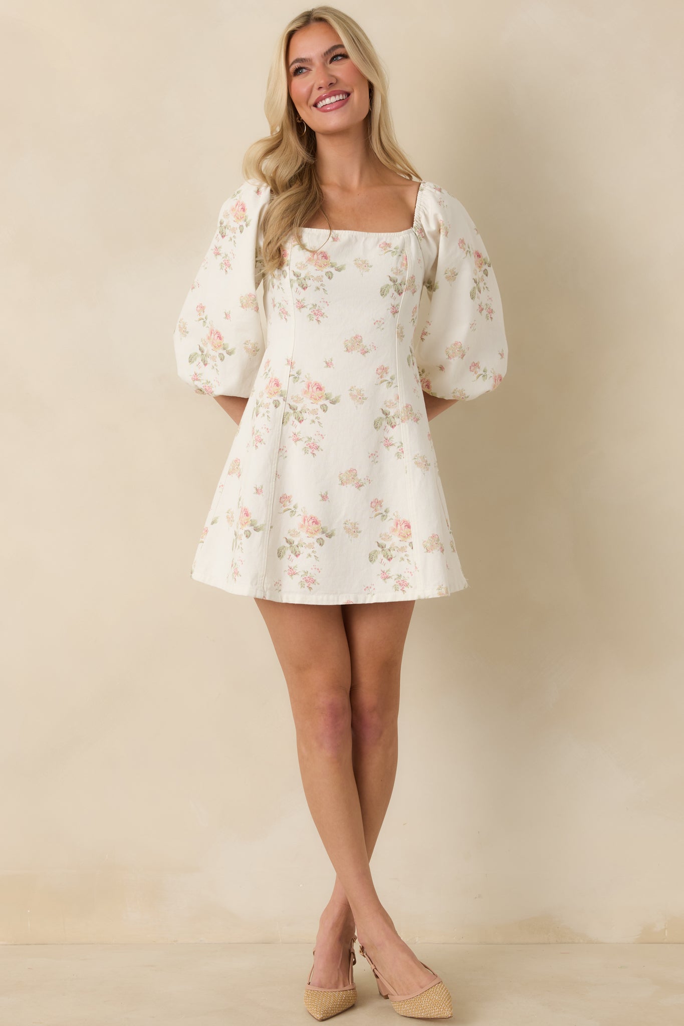 Multi floral cotton mini dress with puff sleeves, fitted bodice, and gently flared hemline.