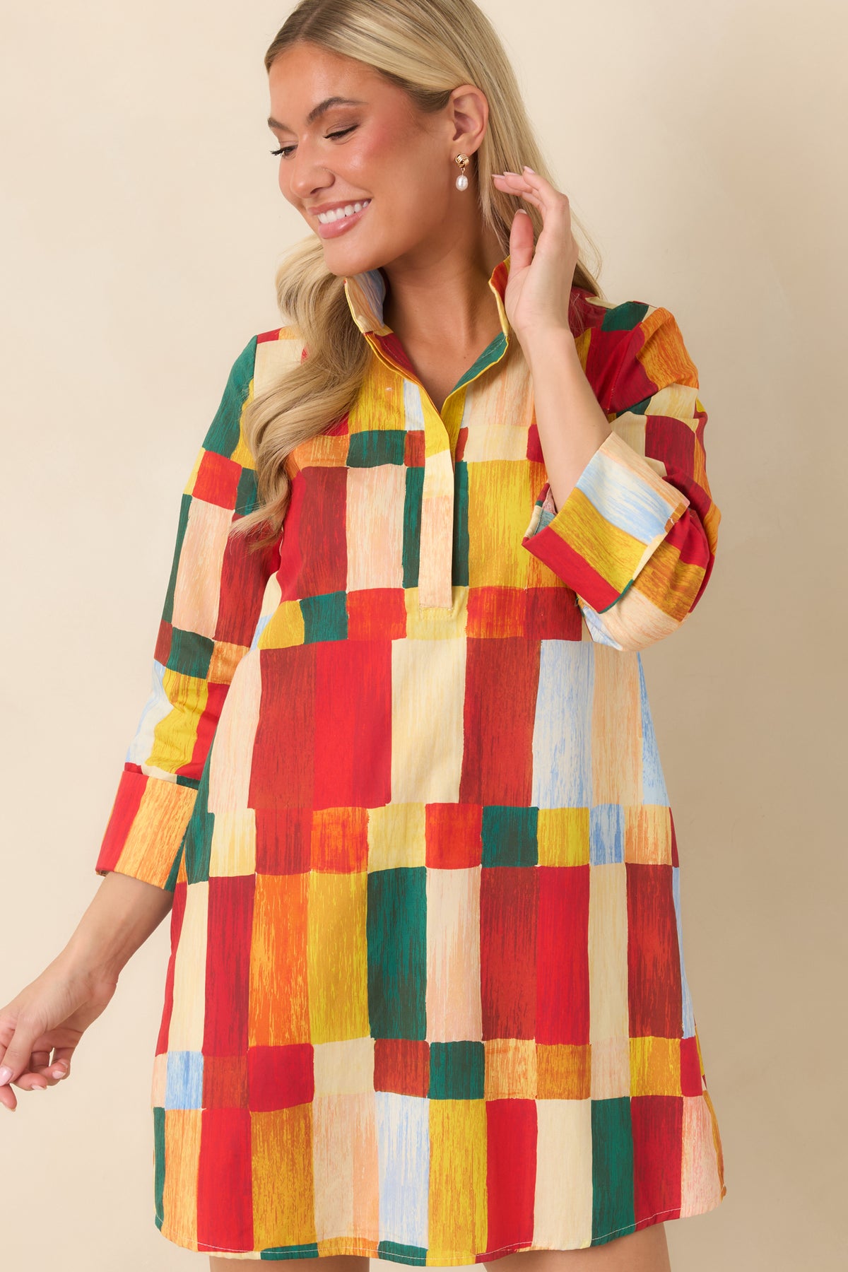 Multicolor abstract print mini dress featuring a standing collar, partial front placket, and bold red, orange, yellow, and green blocks.