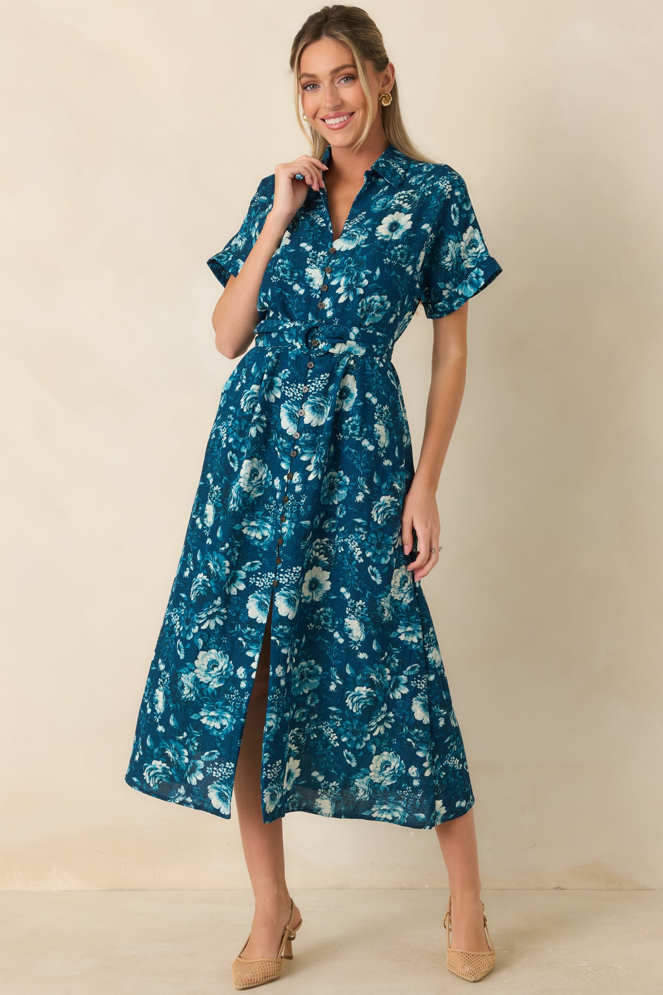 Multicolor floral dress in dark teal with cuffed sleeves, front pockets, and feminine shape.