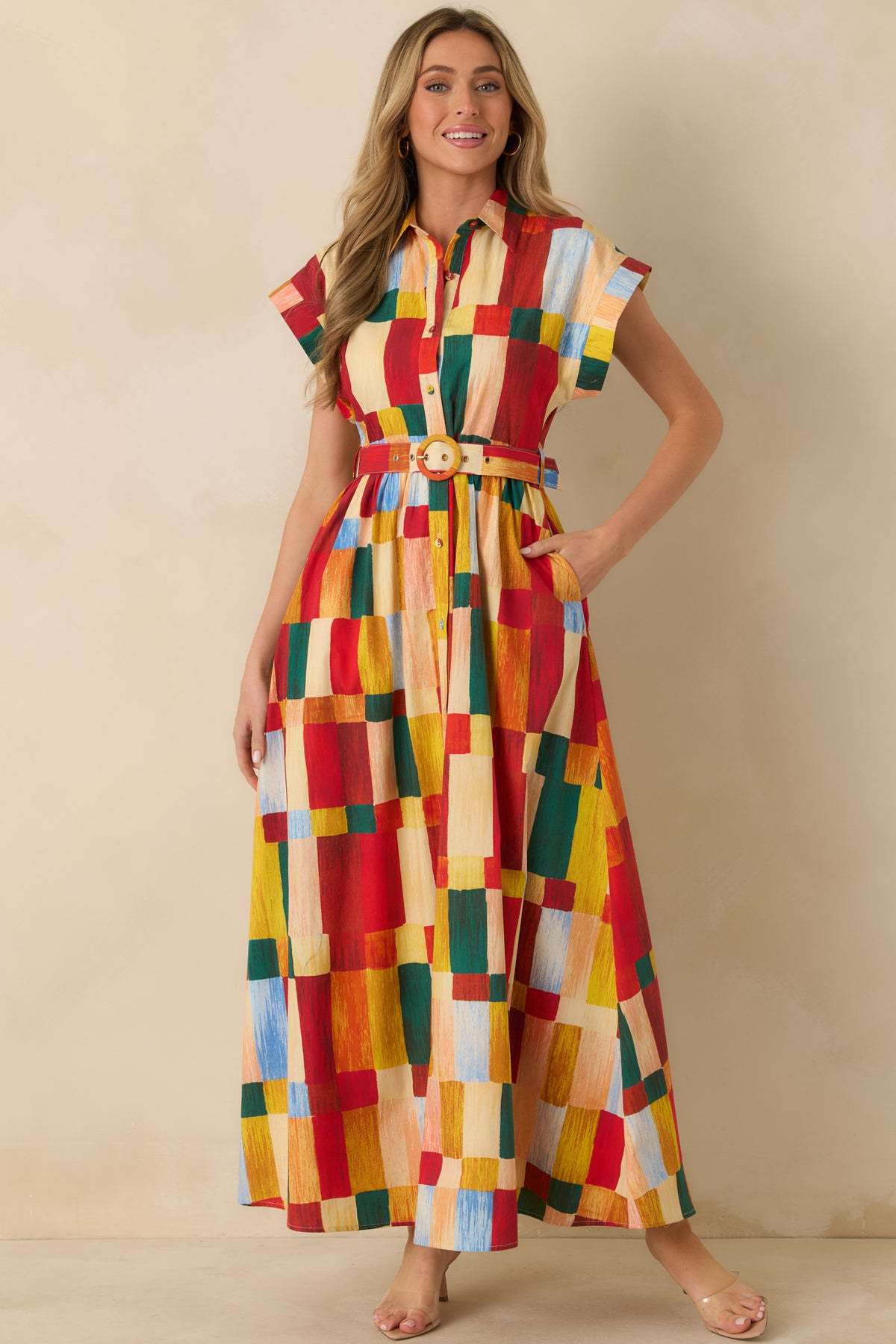 Multicolor geometric print maxi dress with red, yellow, green, and blue blocks, extended cap sleeves, and a belted waist.