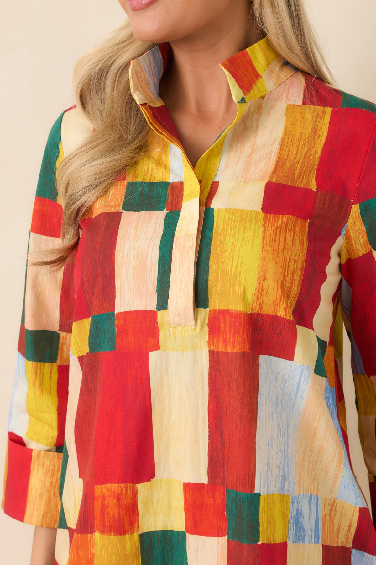 Close-up of multicolor geometric print mini dress featuring a structured standing collar, concealed partial button placket, and vibrant brushstroke pattern.