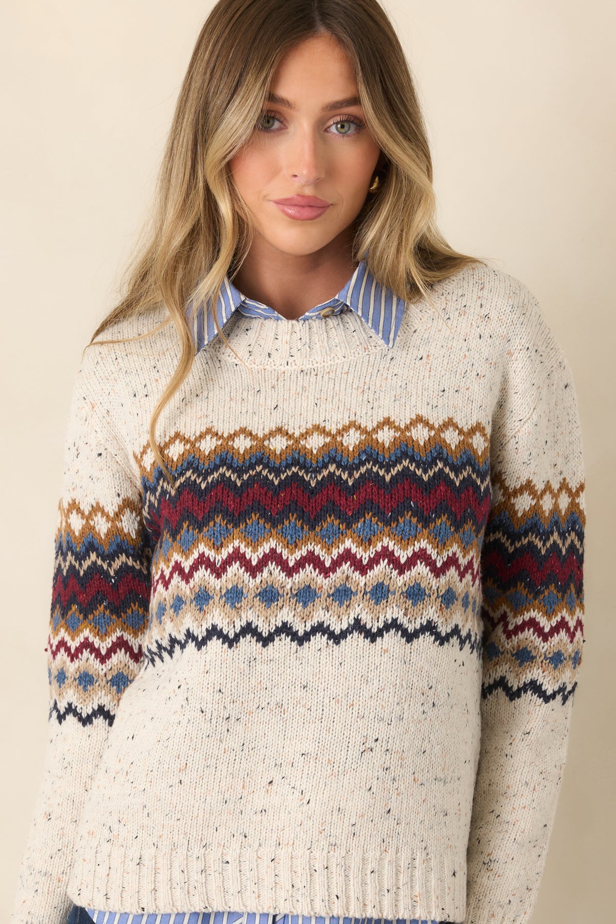 Close view of the multicolor patterned chest and long sleeves against the flecked natural knit backdrop.