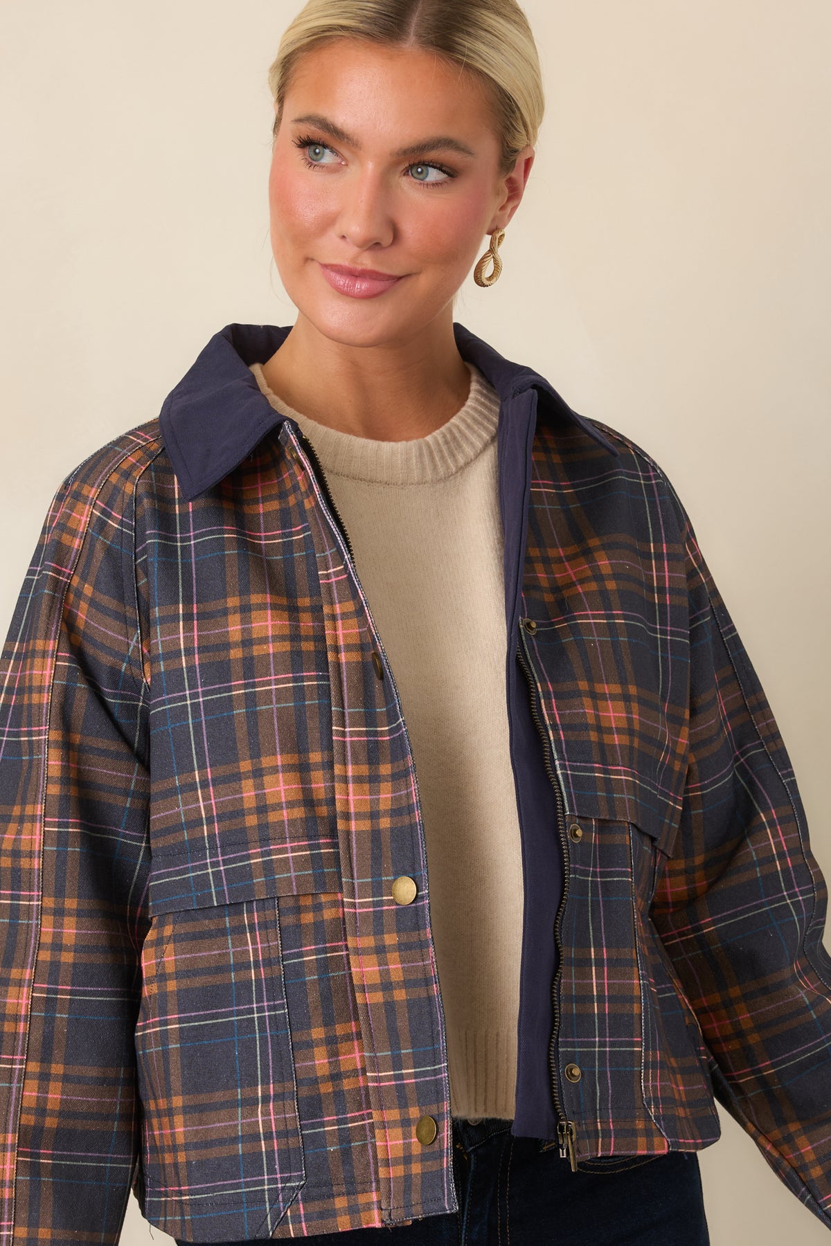 Front pockets complement the relaxed silhouette and vintage utility styling of this multicolor plaid jacket.