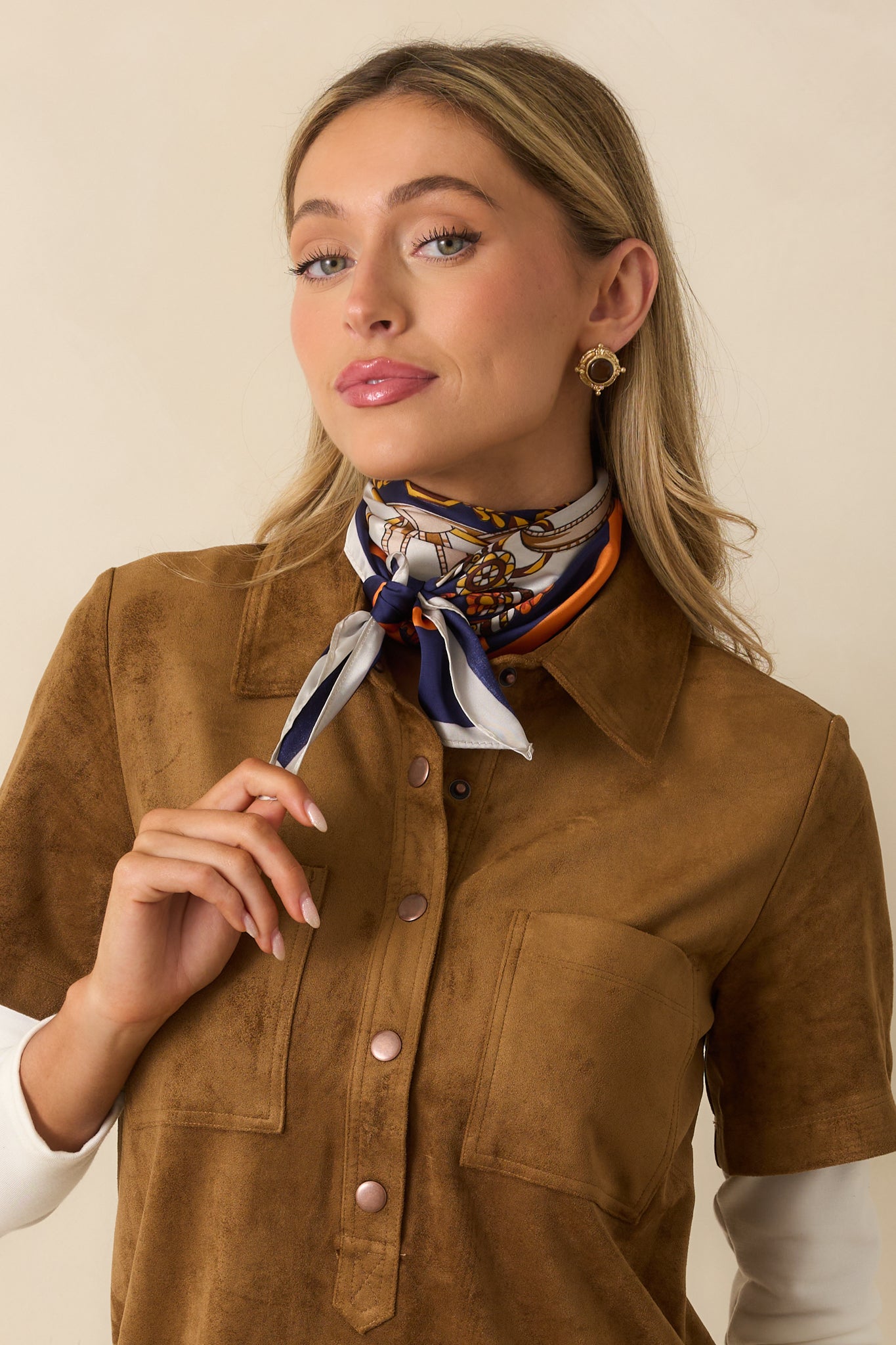 Multicolor chain and belt patterned scarf styled as a neck accessory, framed by a rich orange and gold trim.