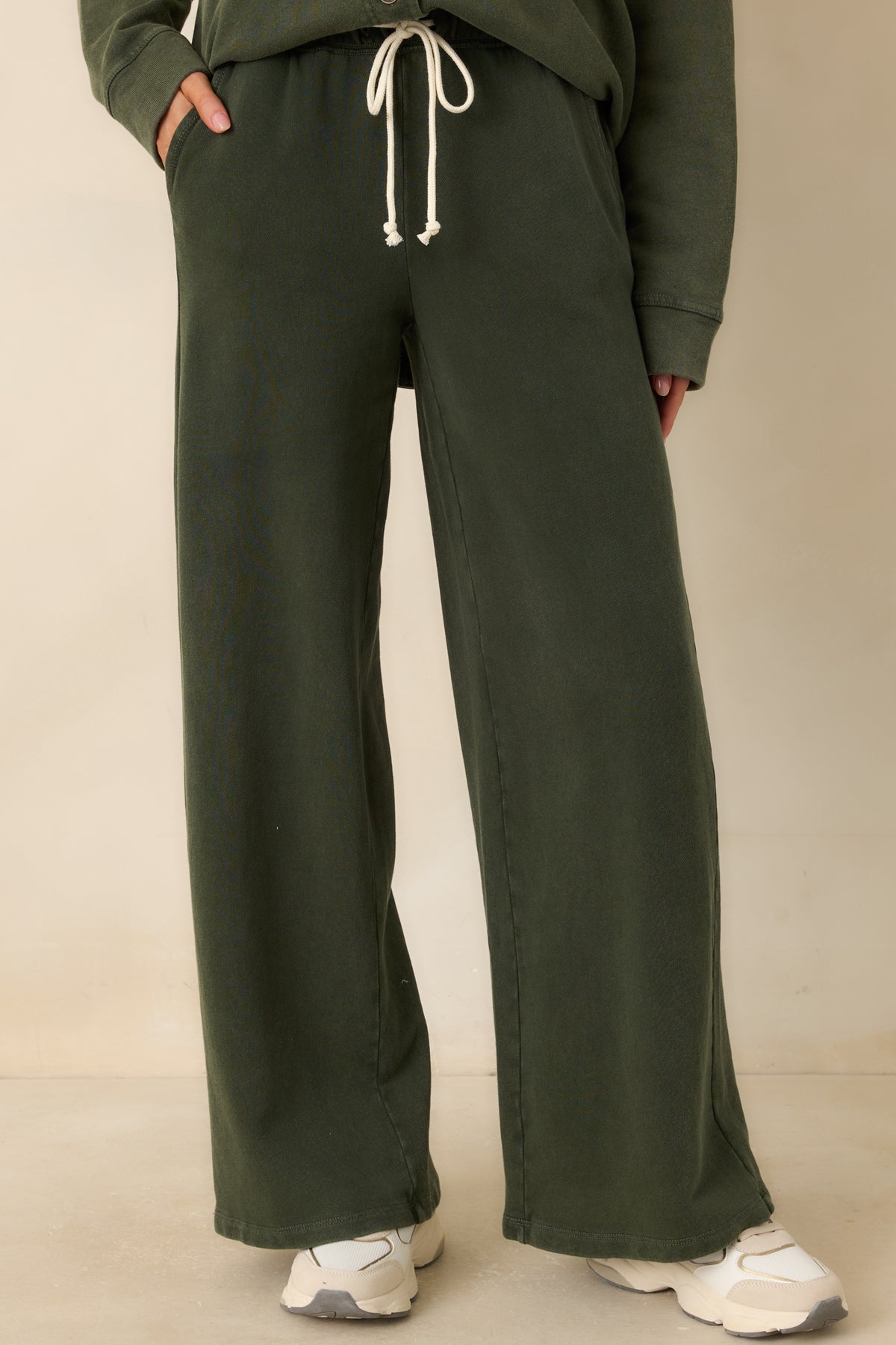 Functional side pockets on the muted olive French terry pants.