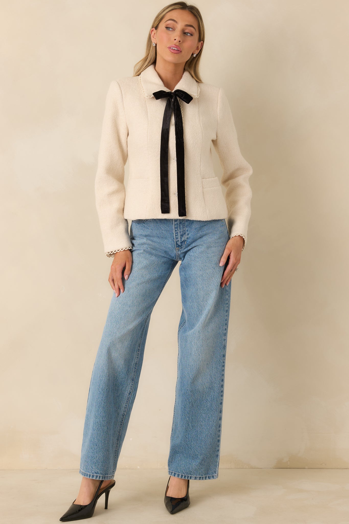 Fully lined natural jacket featuring a lightly structured fit, pearl buttons, and decorative ribbon tie.