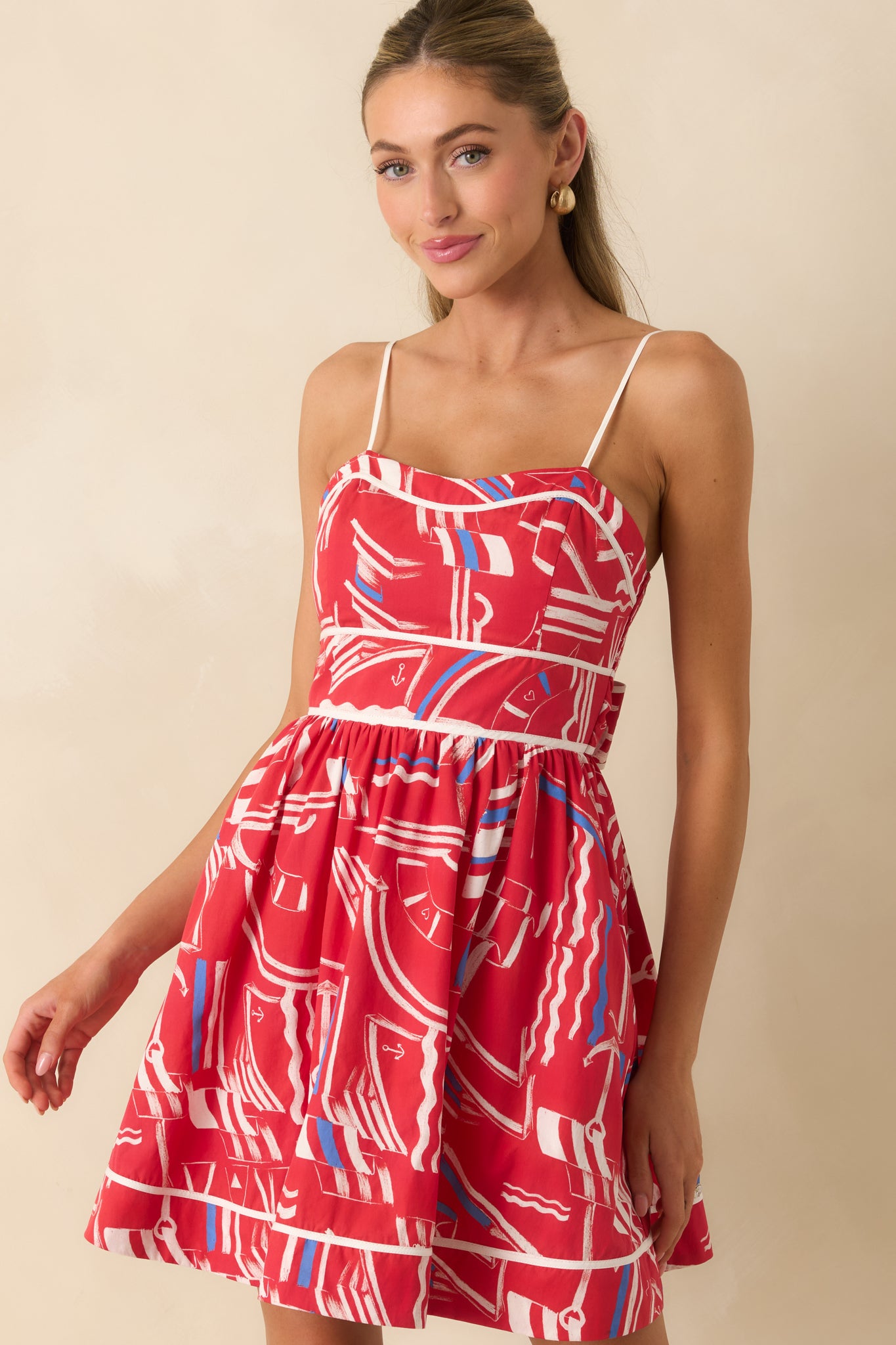 Nautical mini dress showcasing the gathered skirt, contrast piping, and feminine silhouette details.