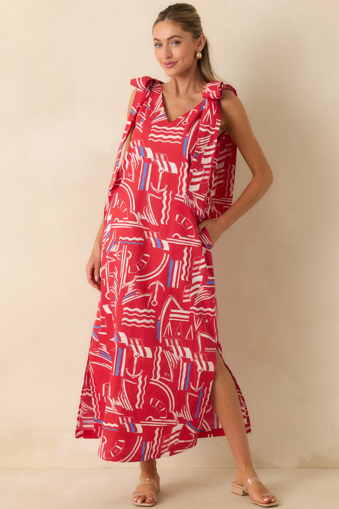Relaxed maxi dress with a vibrant nautical print, oversized bow details, side pockets, and a breezy full-length design.