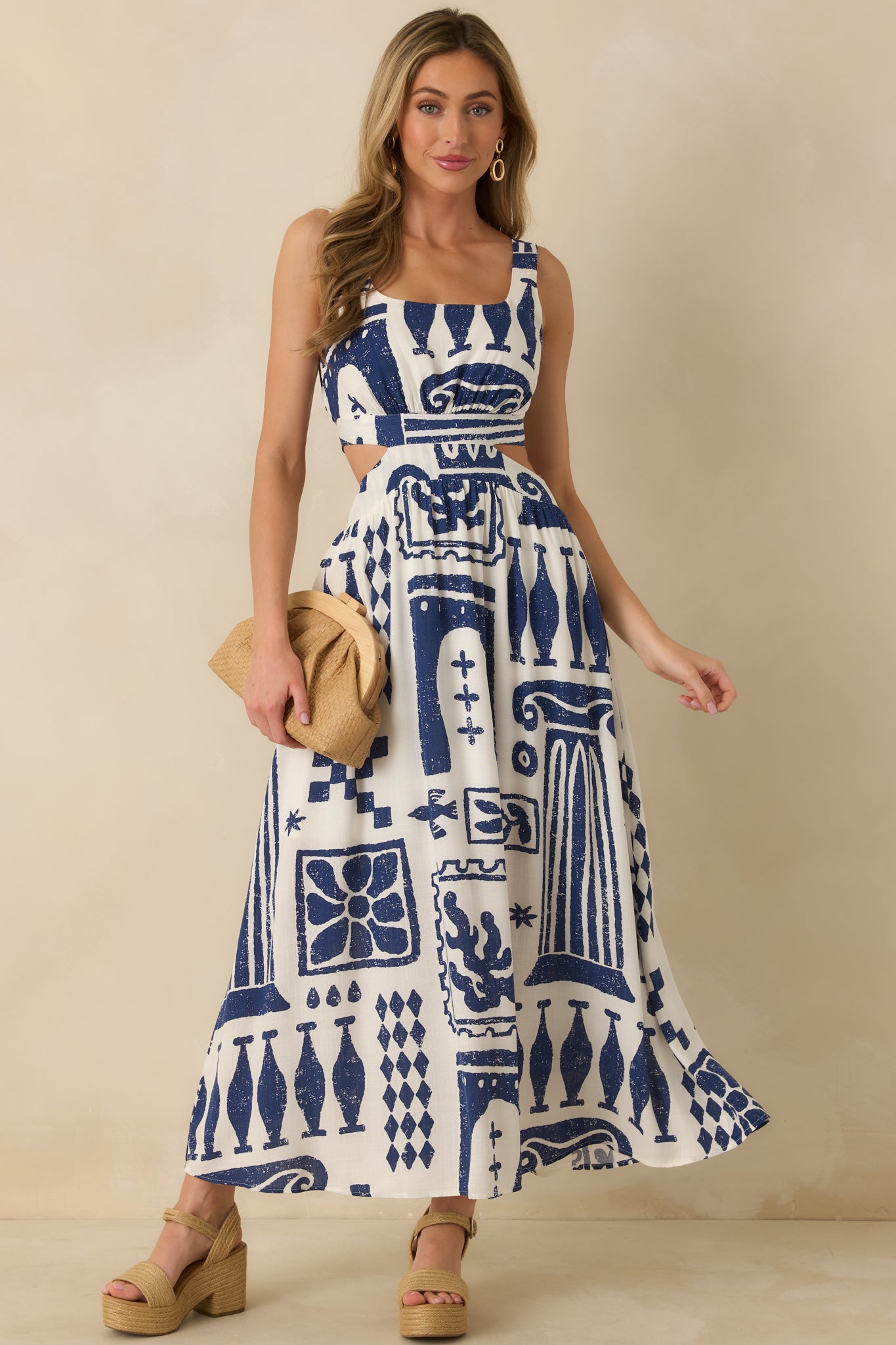 Navy and white maxi dress with square neckline, wide shoulder straps, fitted bodice, and flowing full-length skirt.