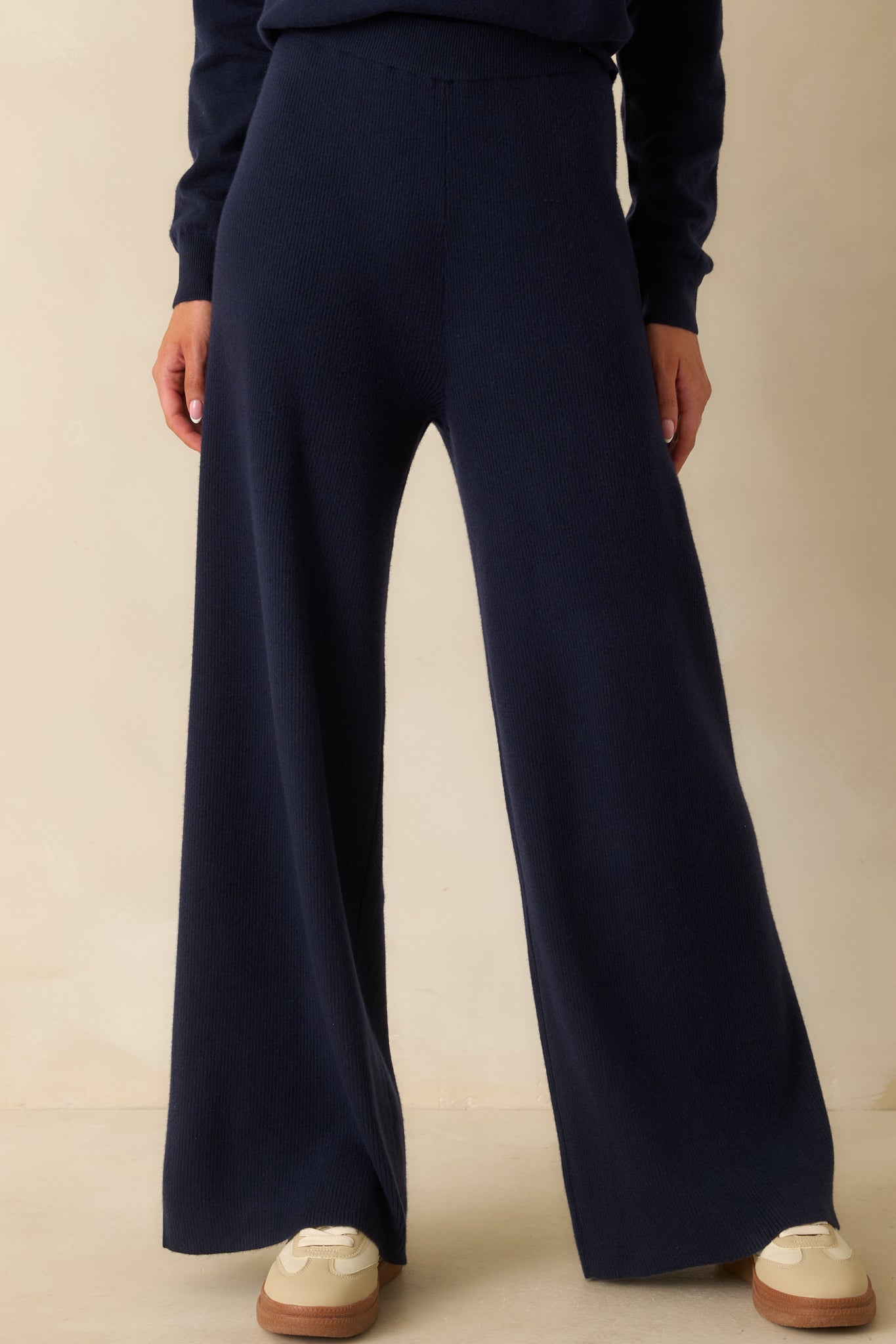 Navy blue knit pants styled in a relaxed wide-leg fit with a high-rise waistband for an easy, polished look.