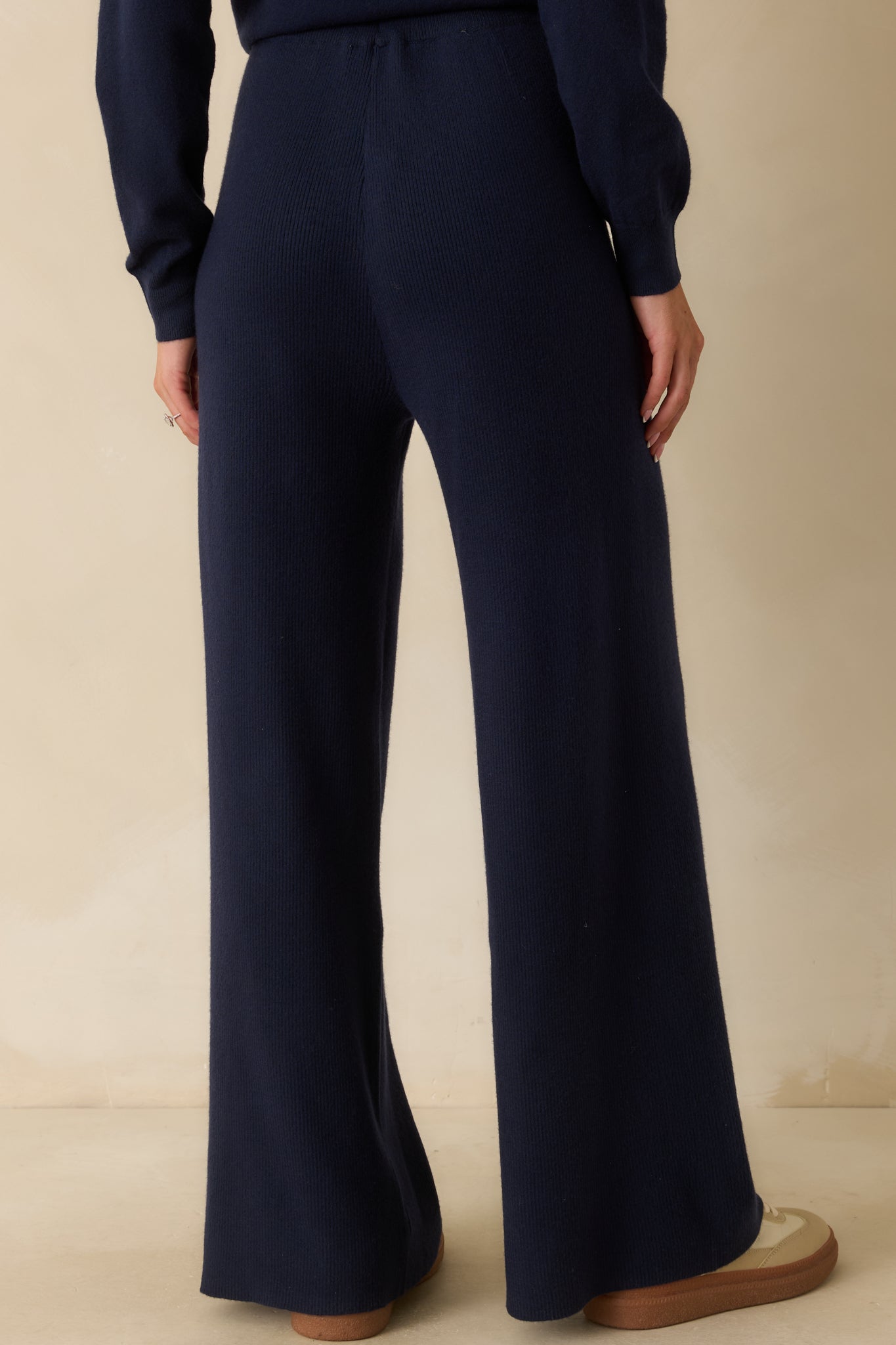 Rear view of the navy blue knit pants displaying the smooth fit and relaxed wide-leg drape.