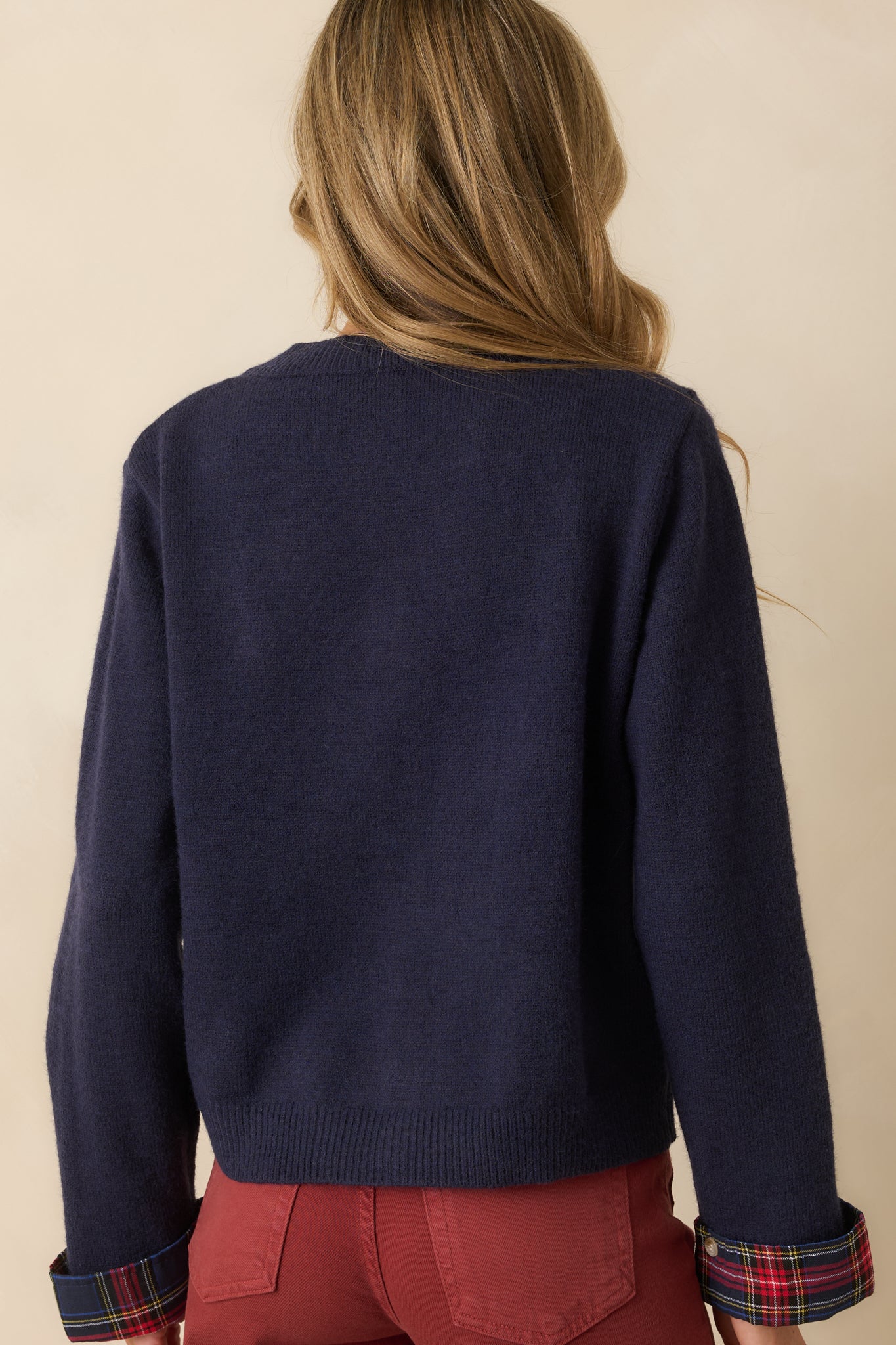 Rear view of the navy cardigan highlighting the smooth knit back and long sleeves.