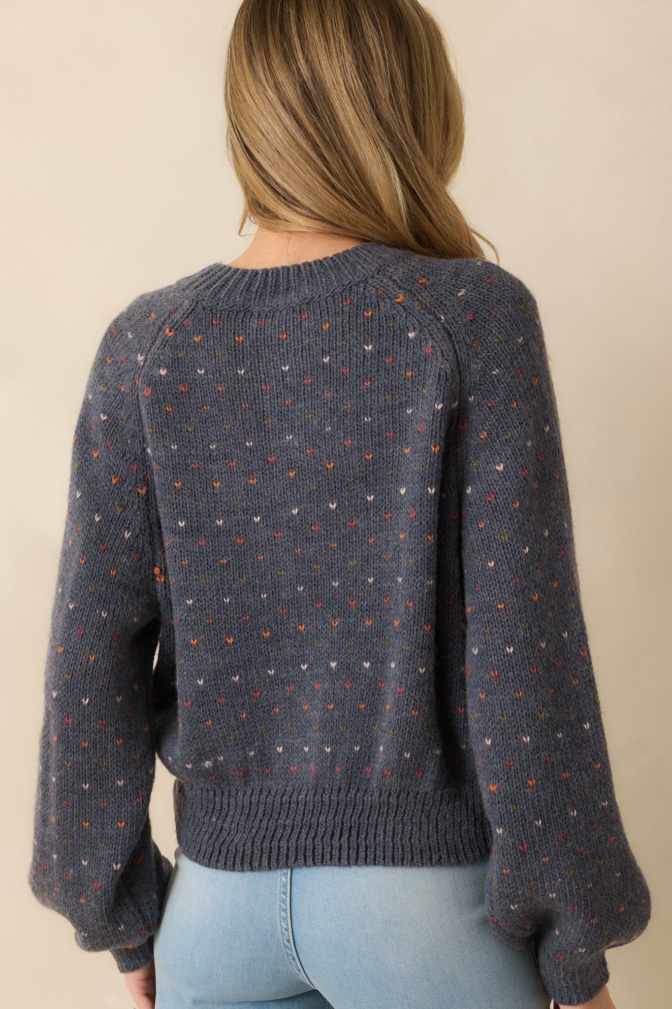 Rear view of the navy cardigan displaying a smooth knit back and ribbed hem finish.