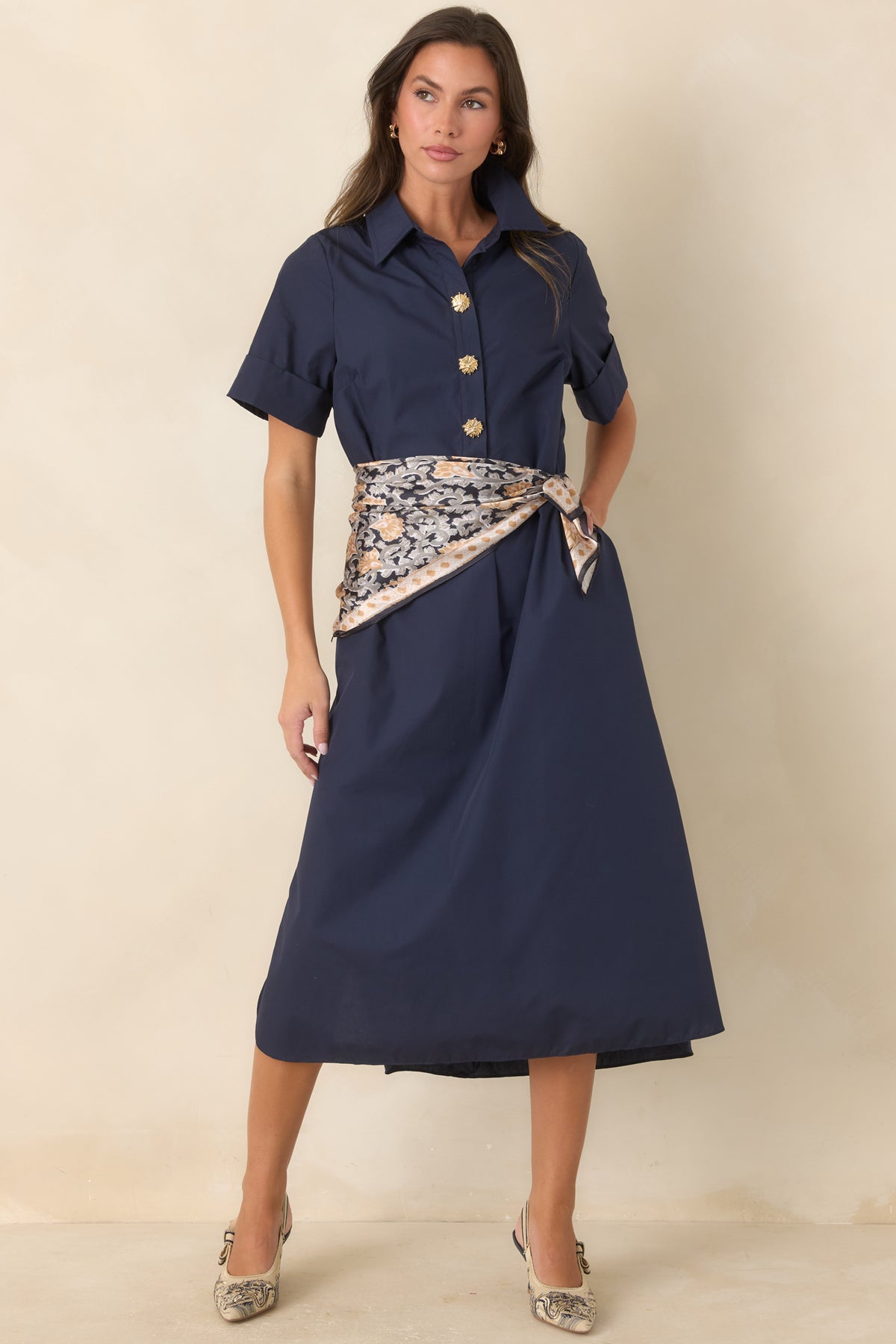 Classic navy shirt dress with a collared neckline, partial button placket, rolled sleeves, and side slits.
