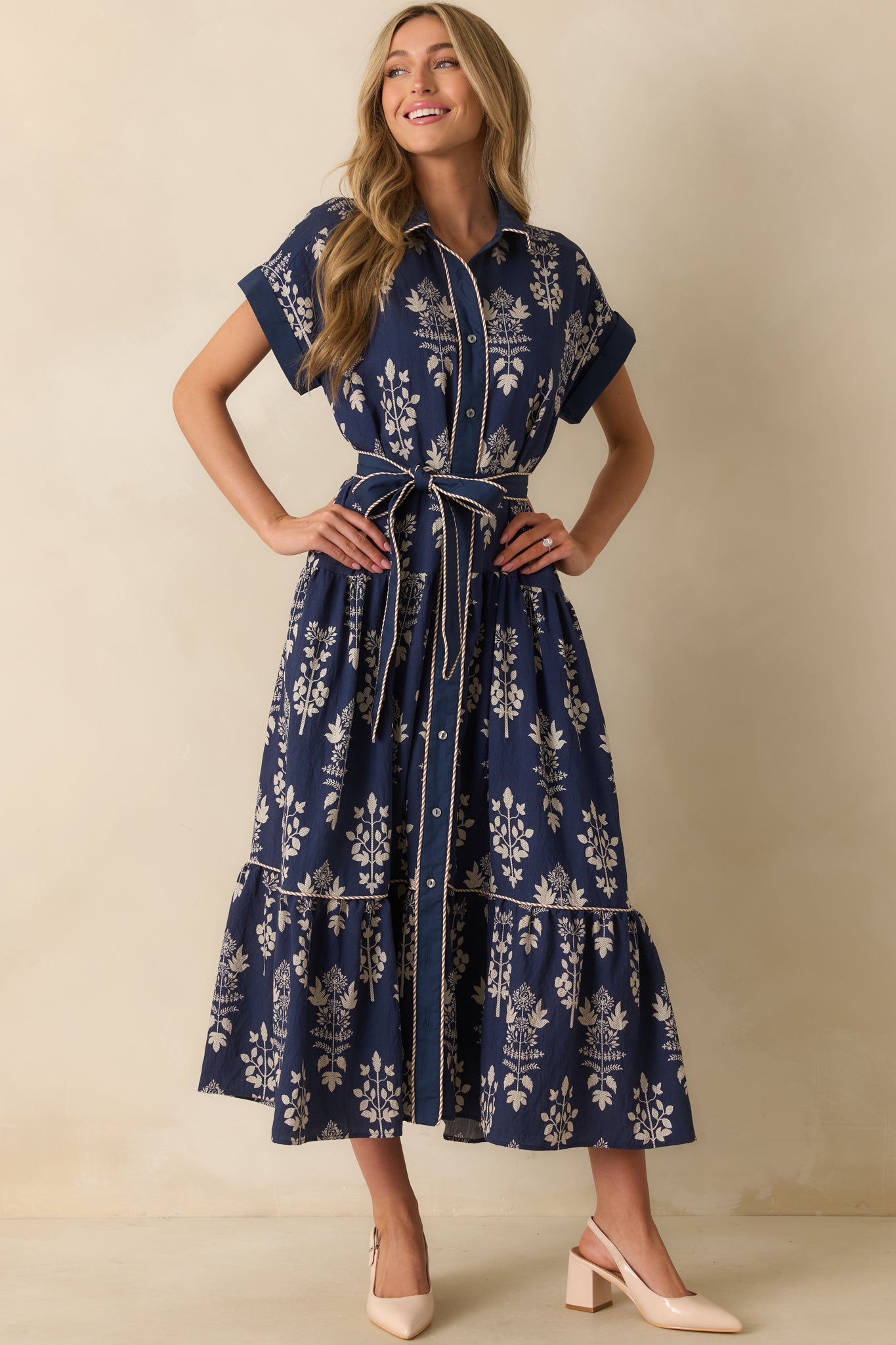 Button-front navy dress with ivory floral pattern, collared neckline, and a self-tie waist belt.