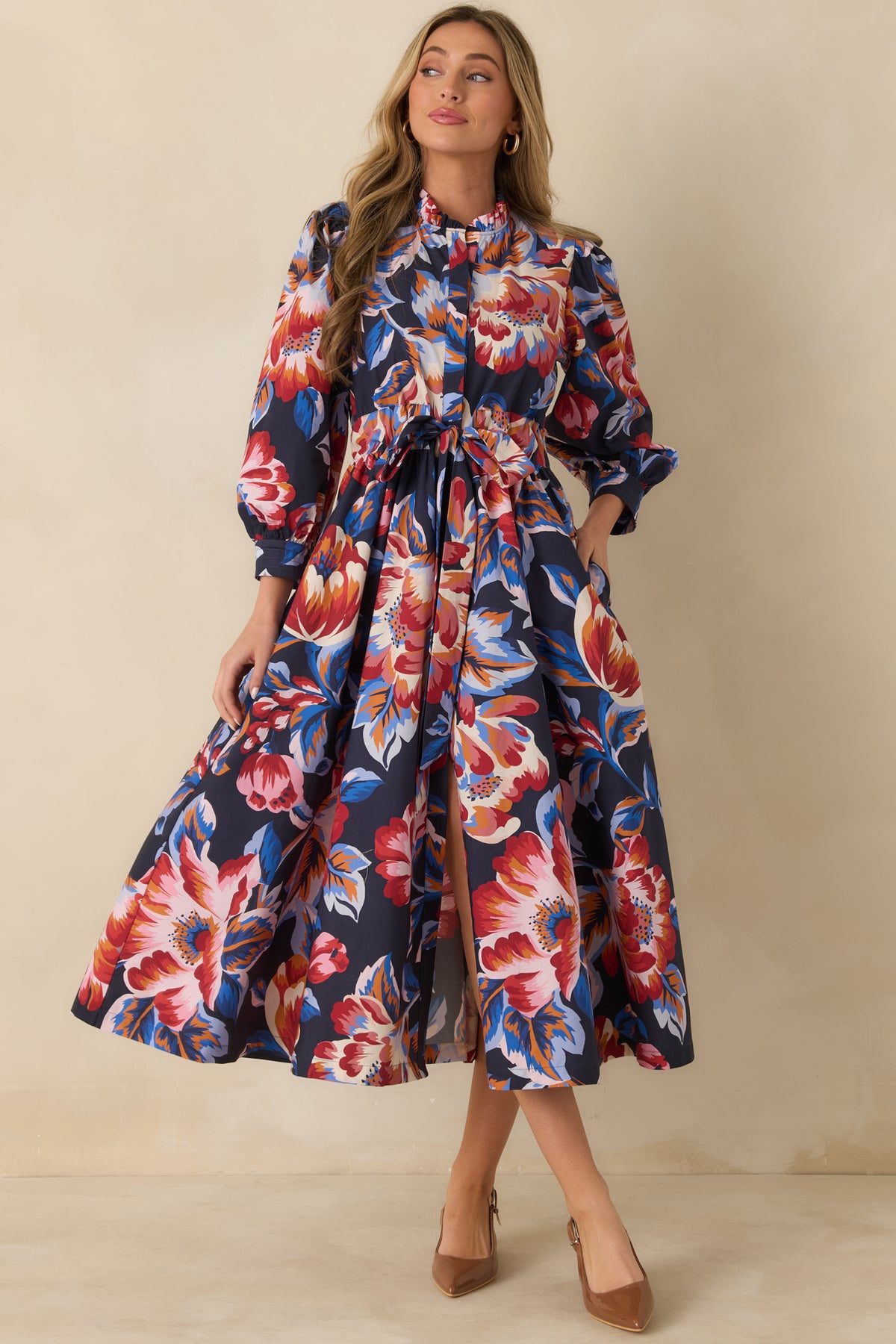 Navy floral midi dress with billowy sleeves, fitted cuffs, and a gathered skirt for added movement.