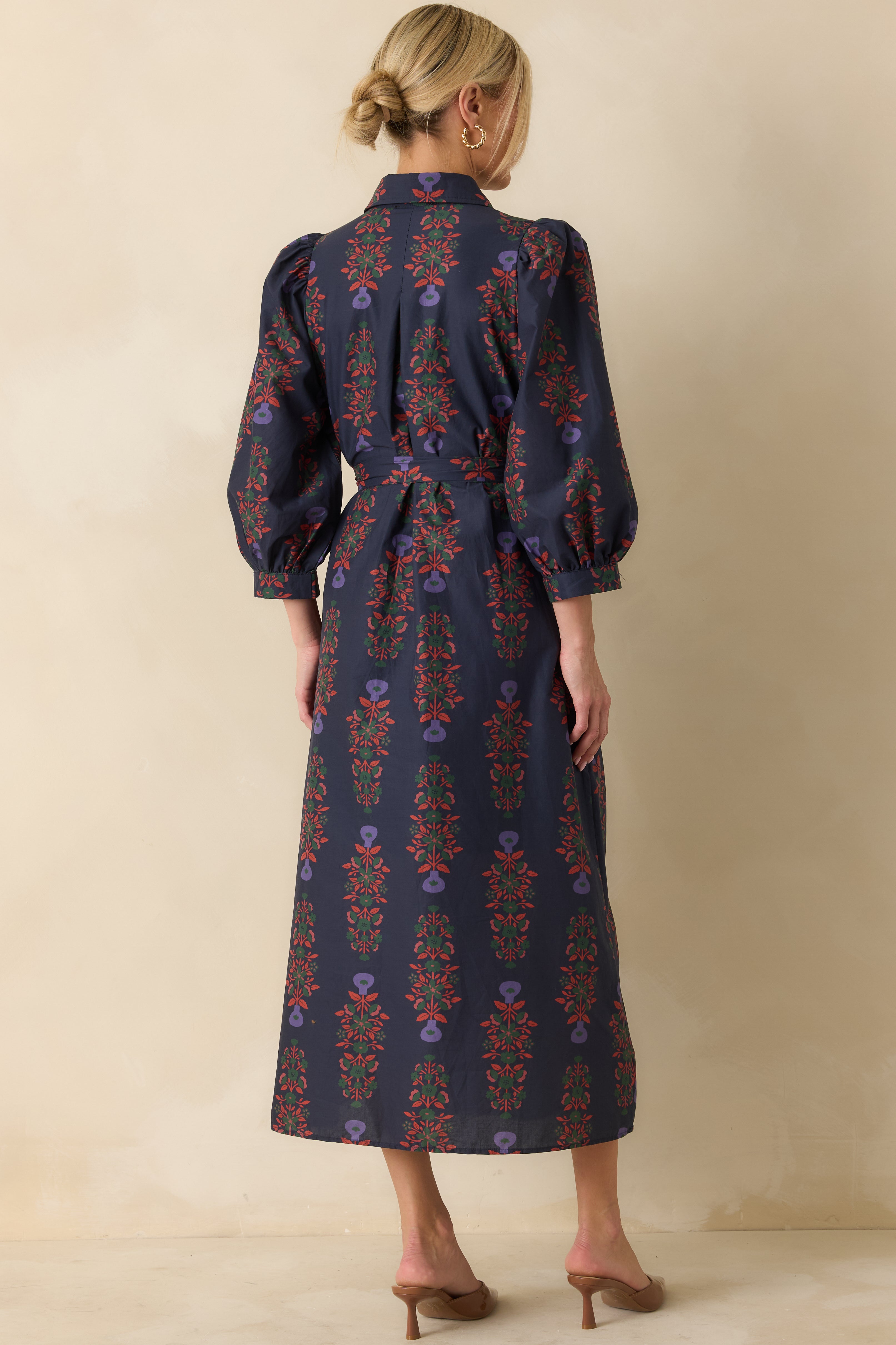Rear view of the navy floral cotton maxi dress showing puff sleeves, self-tie waist, and flowing skirt.