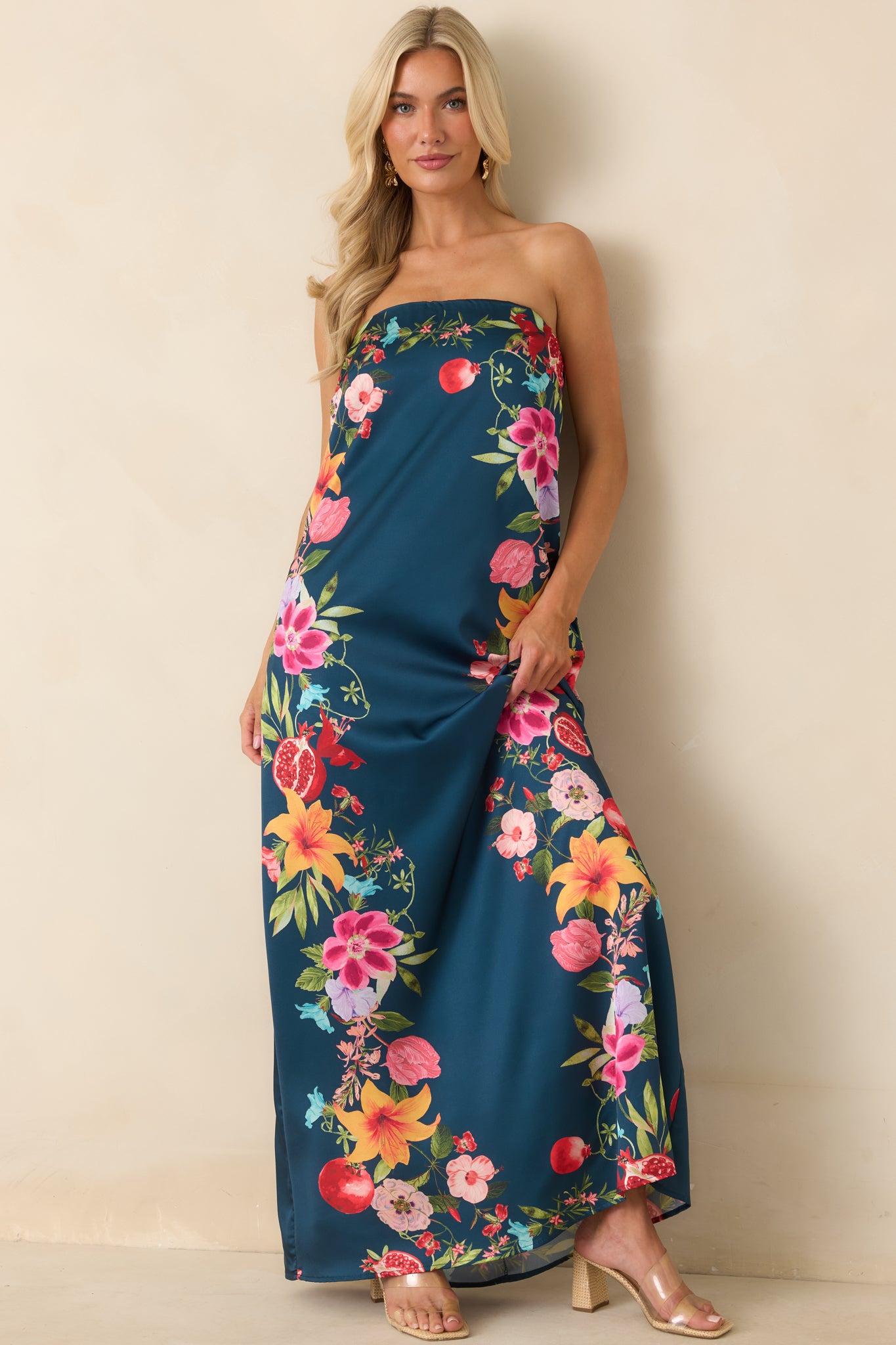 Navy floral maxi dress featuring a strapless neckline, colorful fruit and floral border print, and flowing maxi-length silhouette.