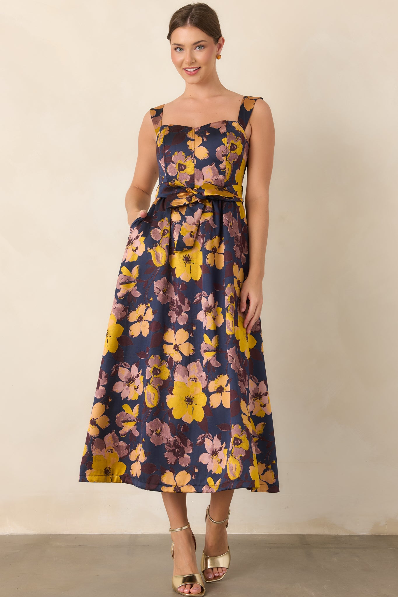 Deep navy floral midi dress featuring a square neckline, wide straps, fitted bodice, and matching tie waist.