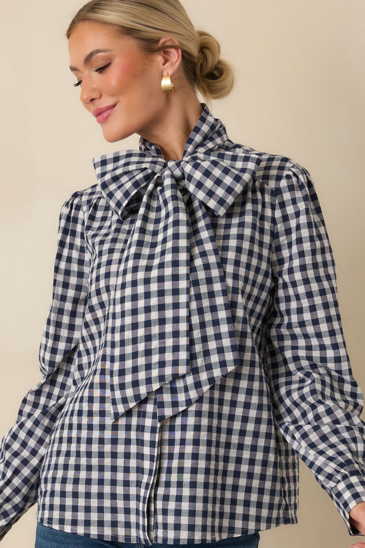 Navy and ivory gingham blouse with a relaxed shape, concealed button placket, and oversized neck tie detailing.