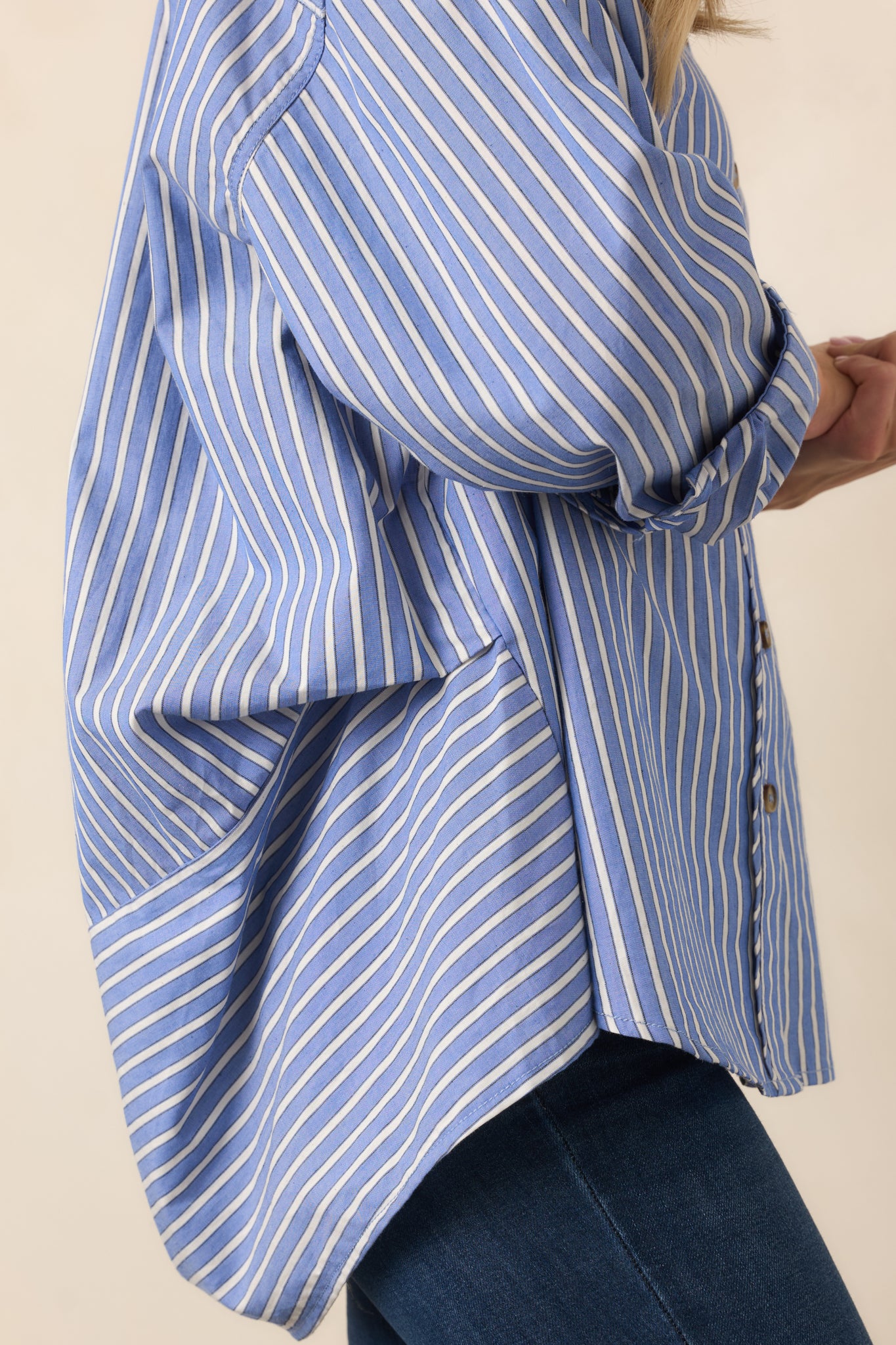 Navy and ivory striped shirt detail emphasizing the long sleeve construction and buttoned cuff.