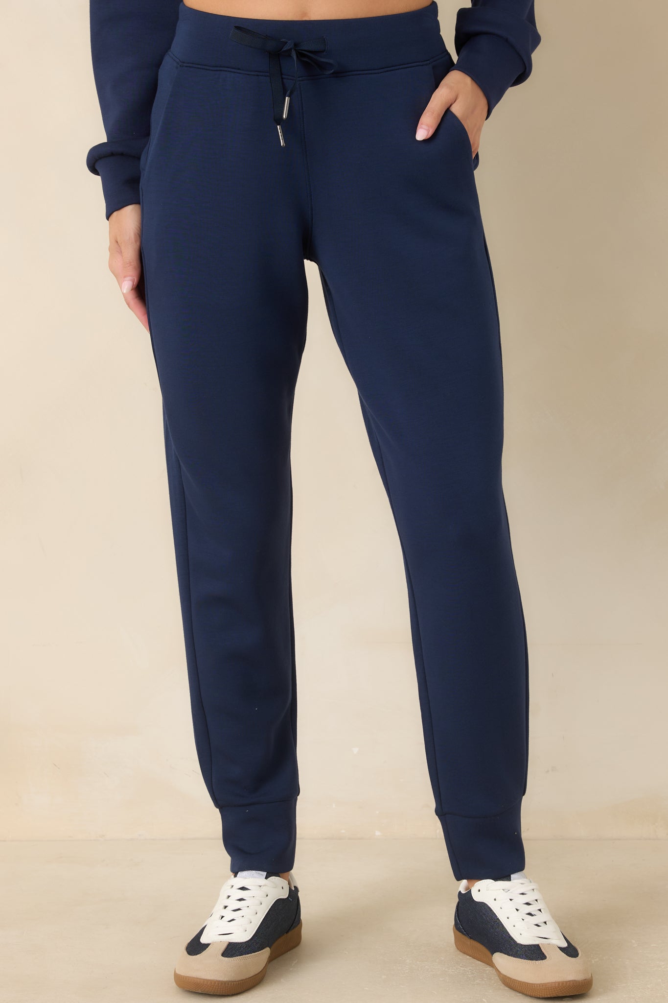Detailed view of the navy jogger pants featuring functional side pockets, soft stretch fabric, and clean construction.