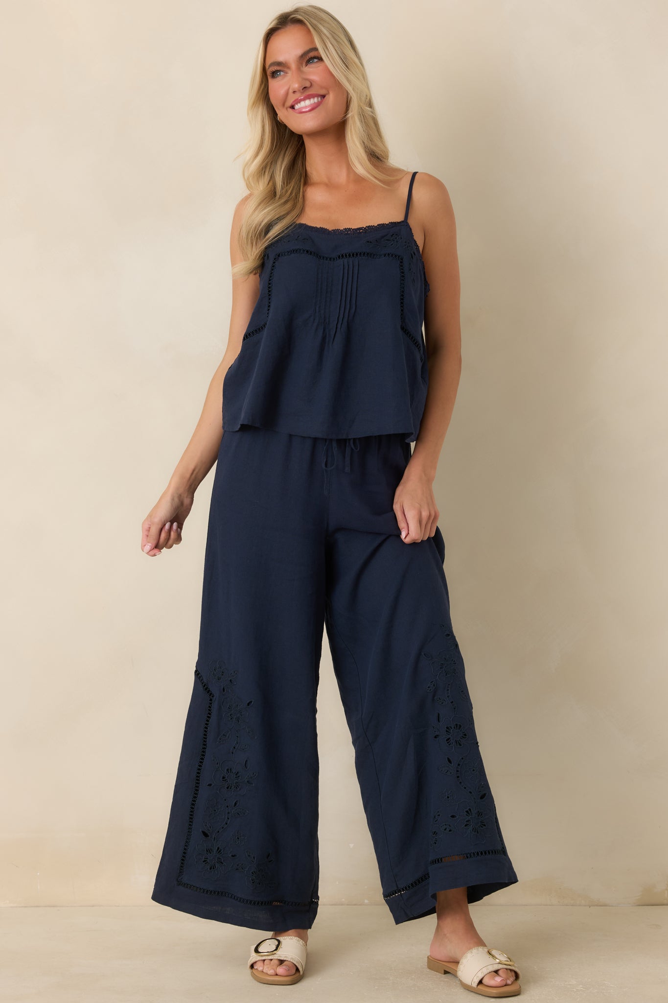 Navy sleeveless top crafted from a linen and rayon blend with delicate floral embroidery and lace-edged neckline.