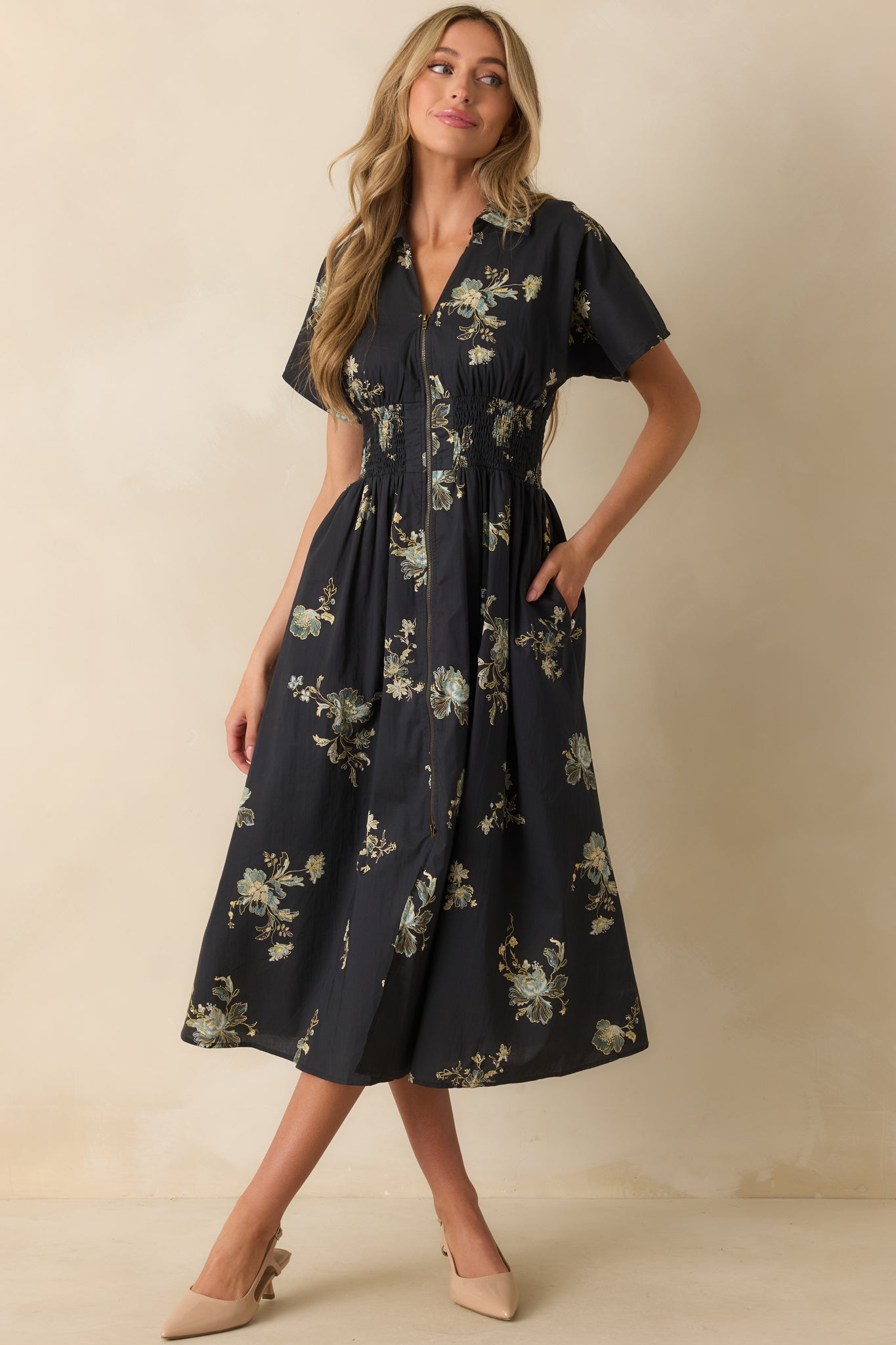 A front view of the navy midi dress featuring a multicolor floral print, collared v-neckline, and short sleeves.