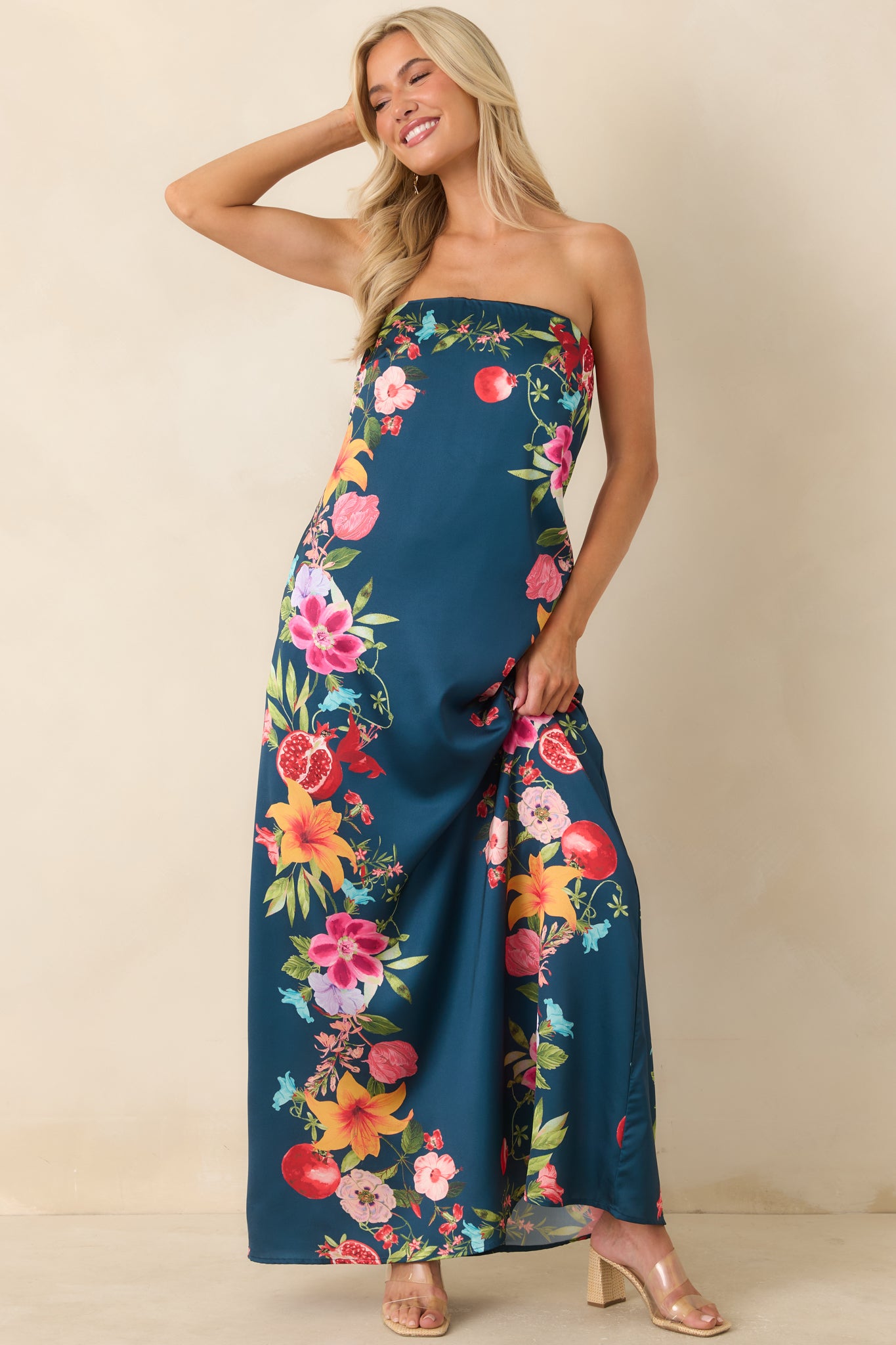 Navy multi floral maxi dress featuring a vibrant border print, strapless silhouette, and graceful flowing length for an effortless statement look.