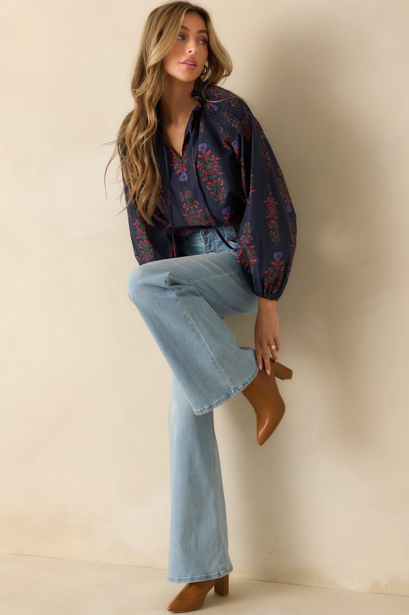 Navy multi floral peasant top with a relaxed fit, split neckline with optional ties, and long puff sleeves with elastic cuffs.