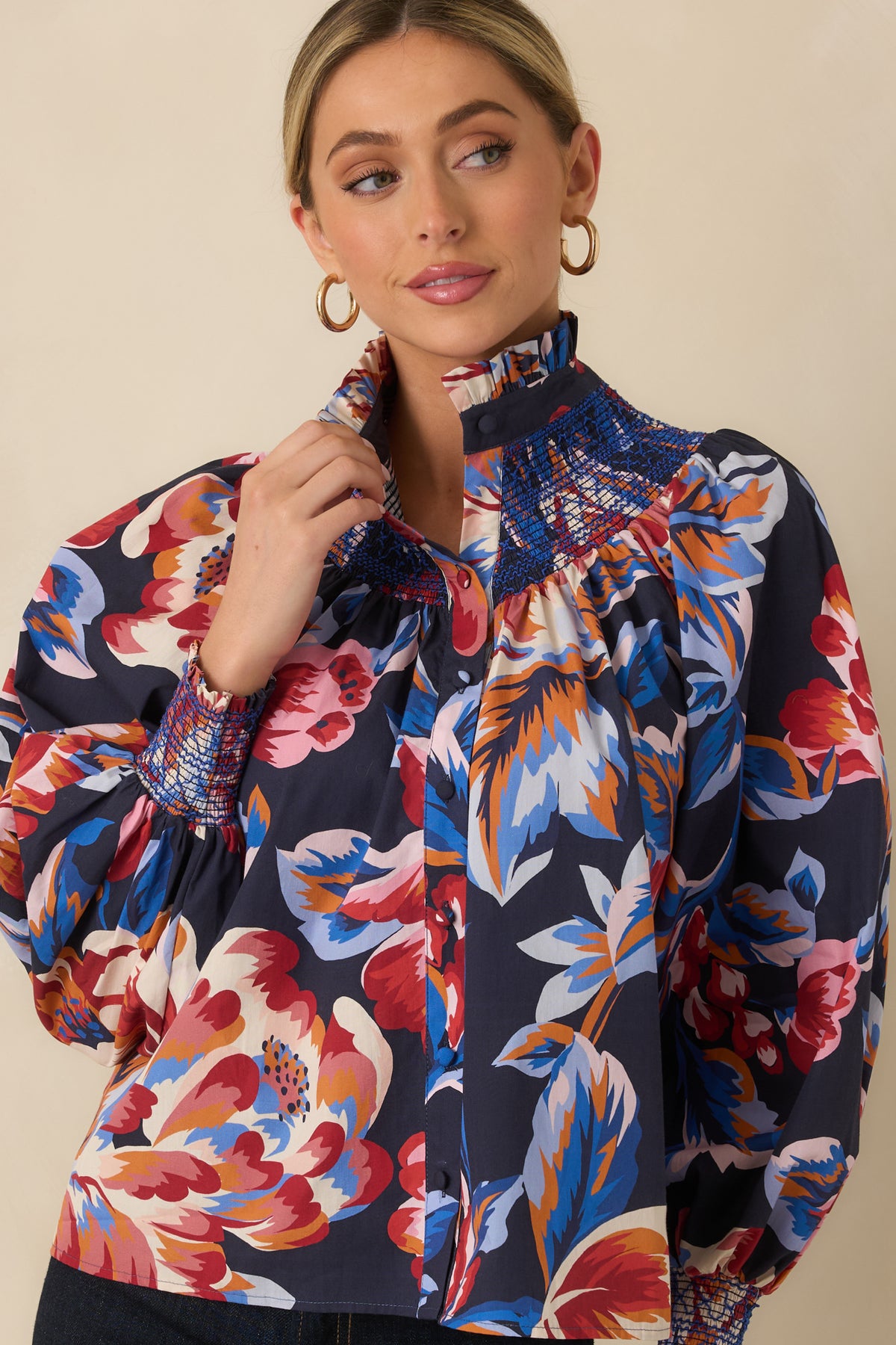 Close view of the oversized pink, red, blue, orange, and ivory floral pattern against the deep navy cotton fabric.