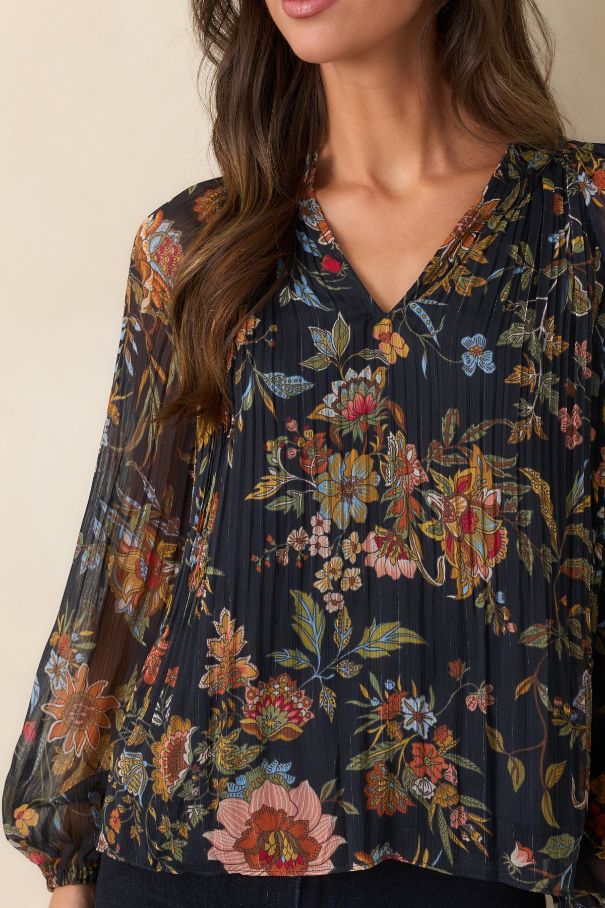 Close-up of the pleated texture, split V-neckline, gathered ruffles, and colorful botanical print.