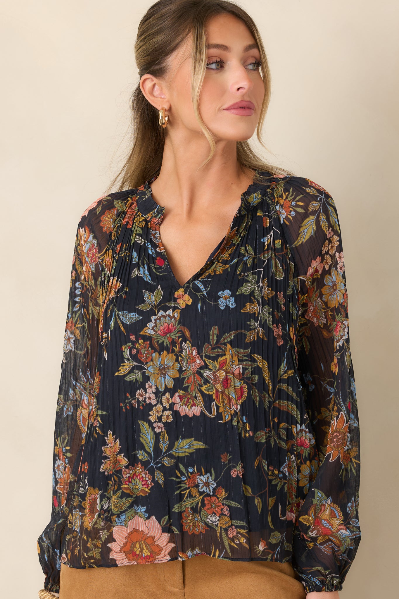 Detailed view of the pleated navy fabric adorned with rust, camel, pink, blue, and olive botanical motifs.