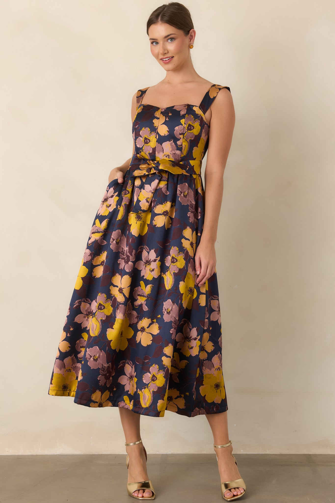 Printed midi dress featuring colorful florals against a navy background and a feminine softly gathered silhouette.