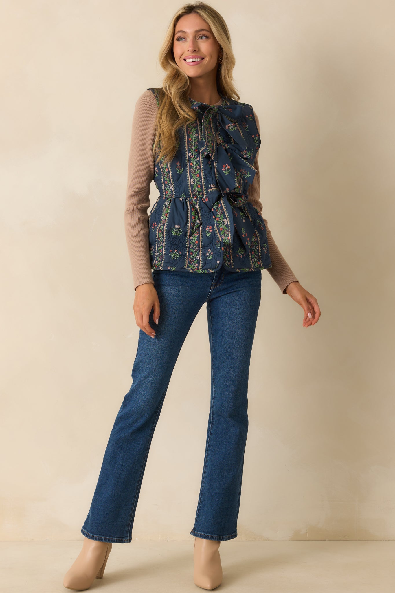 Navy quilted vest with multicolor floral print and crew neckline.