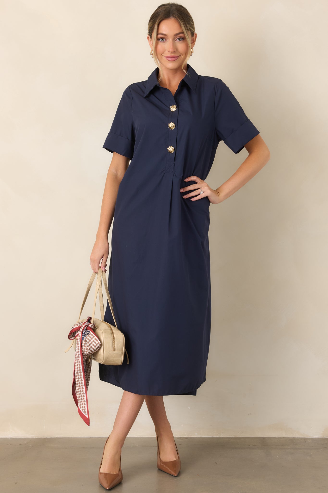 Classic navy shirt dress with statement gold floral buttons, side pockets, and a comfortable relaxed silhouette.