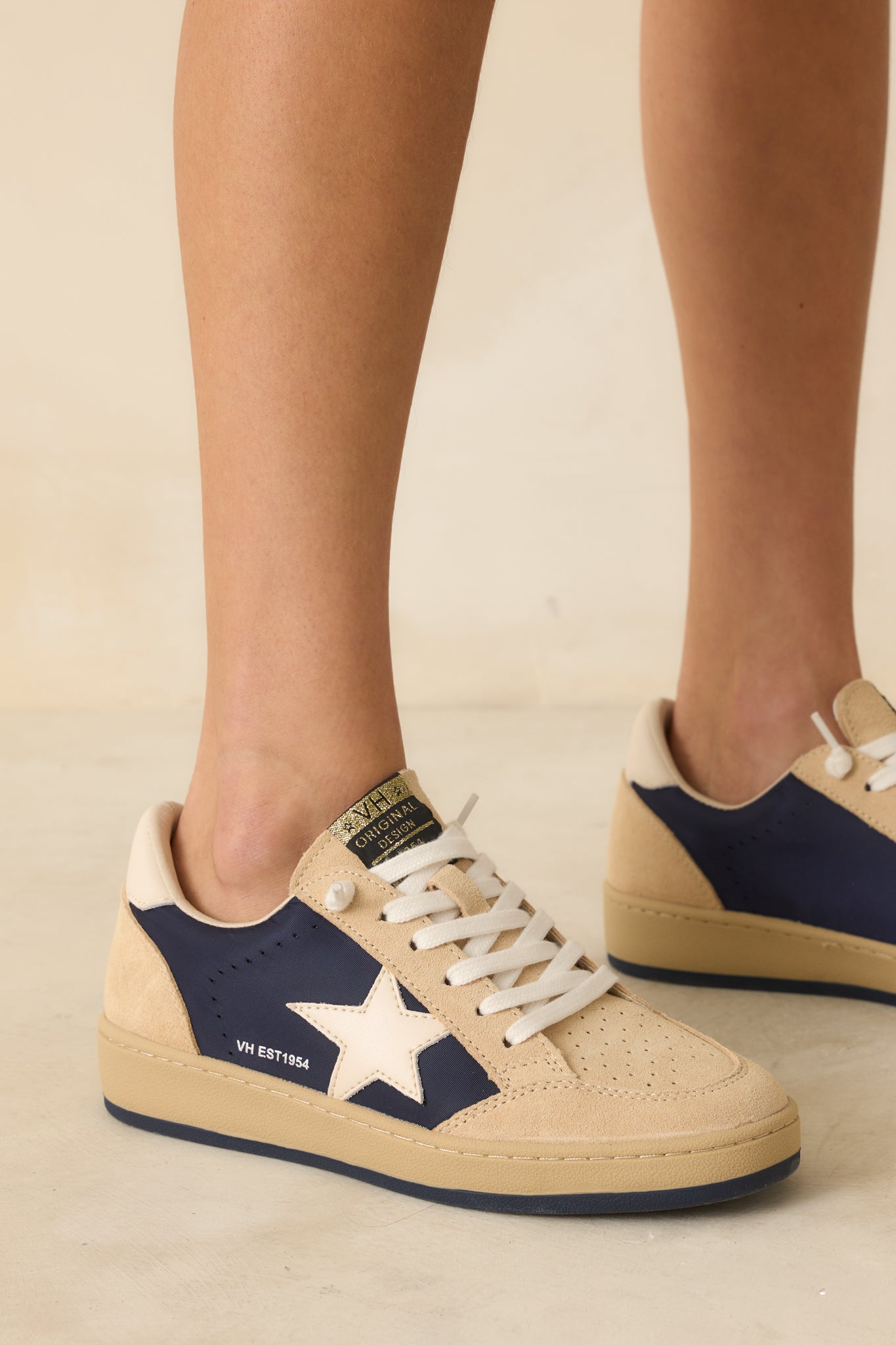Side view of the sneakers highlighting the navy signature star logo patch and smooth suede overlays.