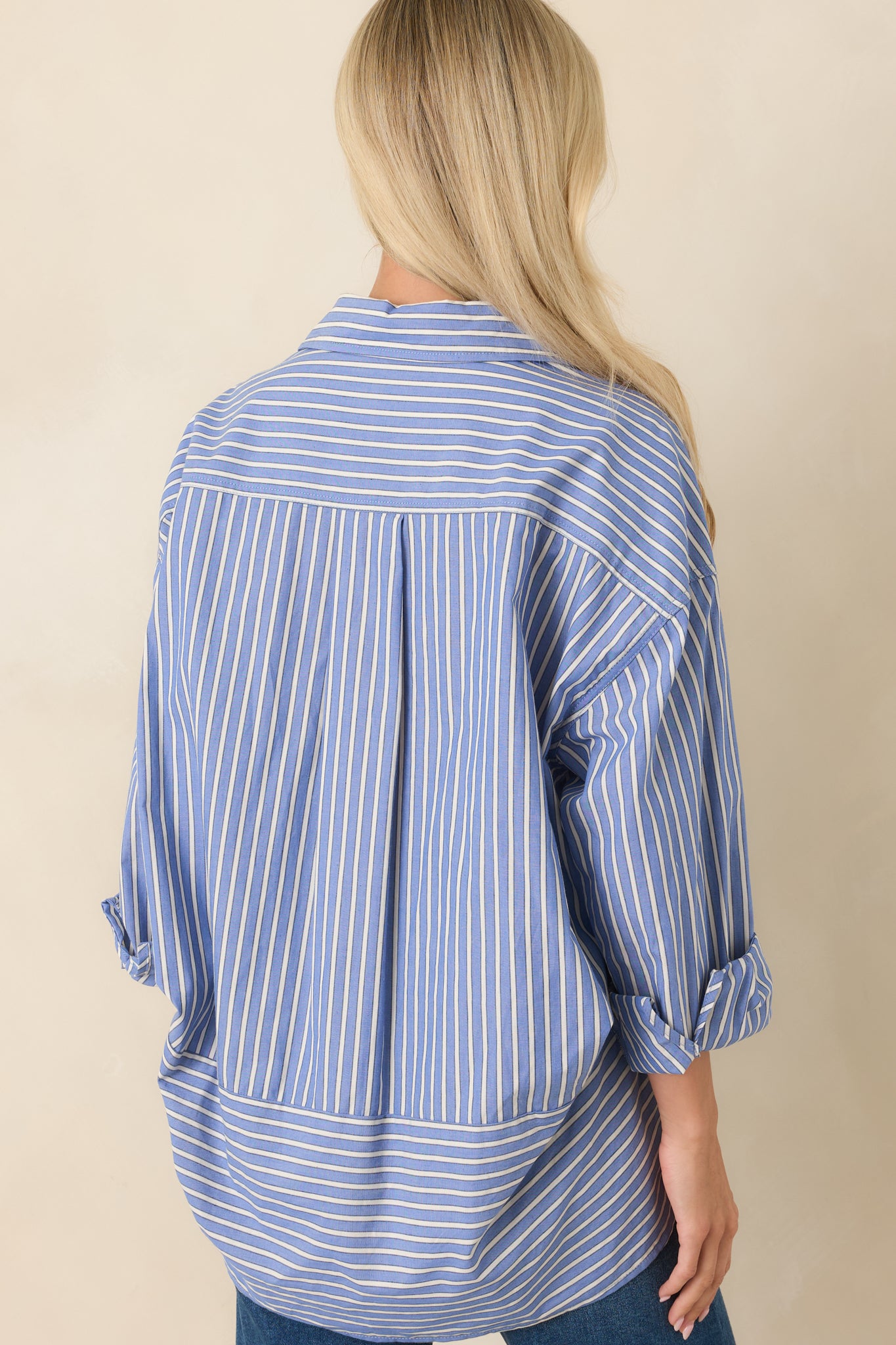 Rear view of the navy stripe button-up shirt featuring a relaxed silhouette and curved hemline.