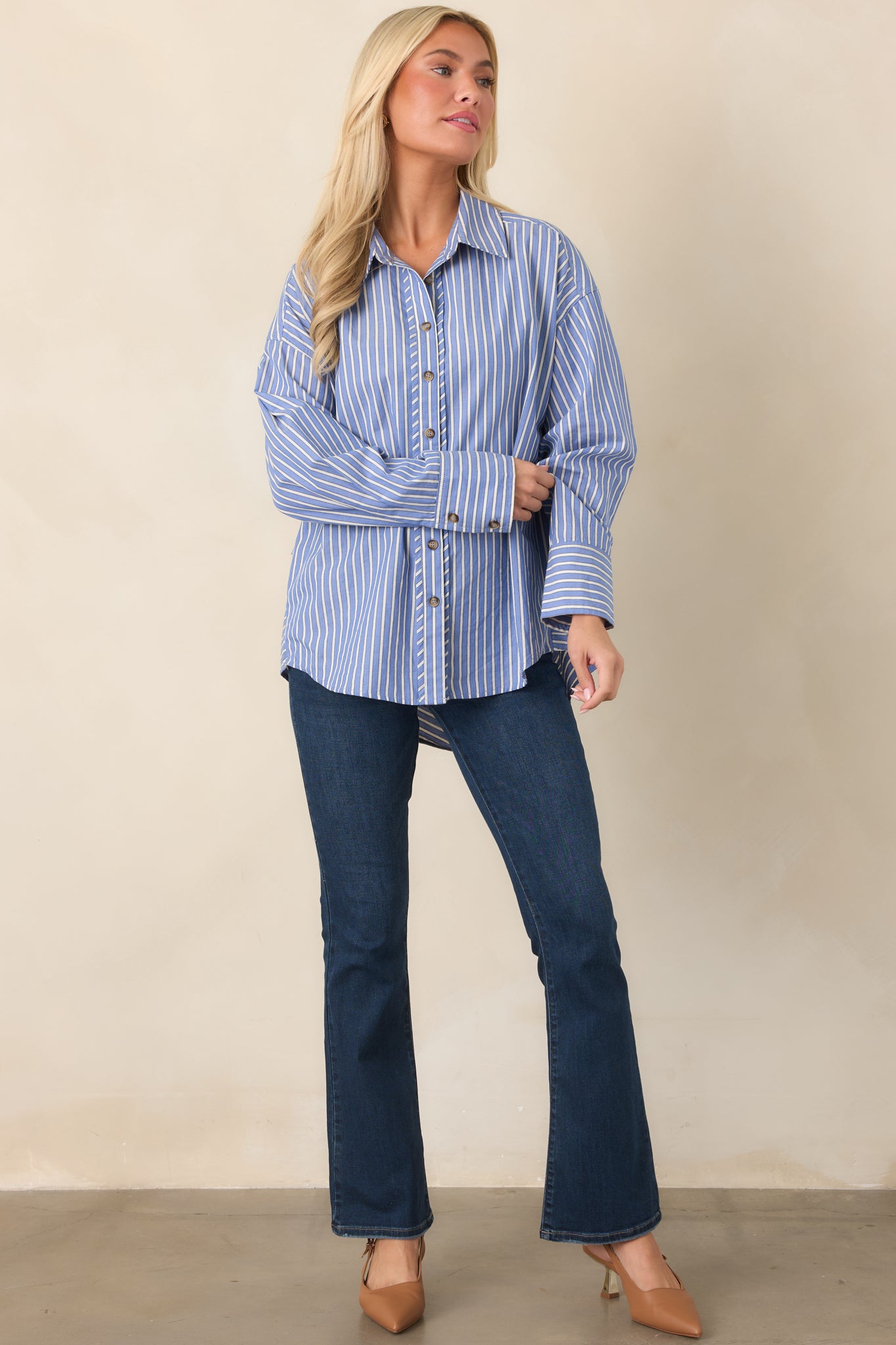 Relaxed-fit navy button-up shirt featuring contrasting ivory stripes, button cuffs, a structured collar, and curved bottom hem.