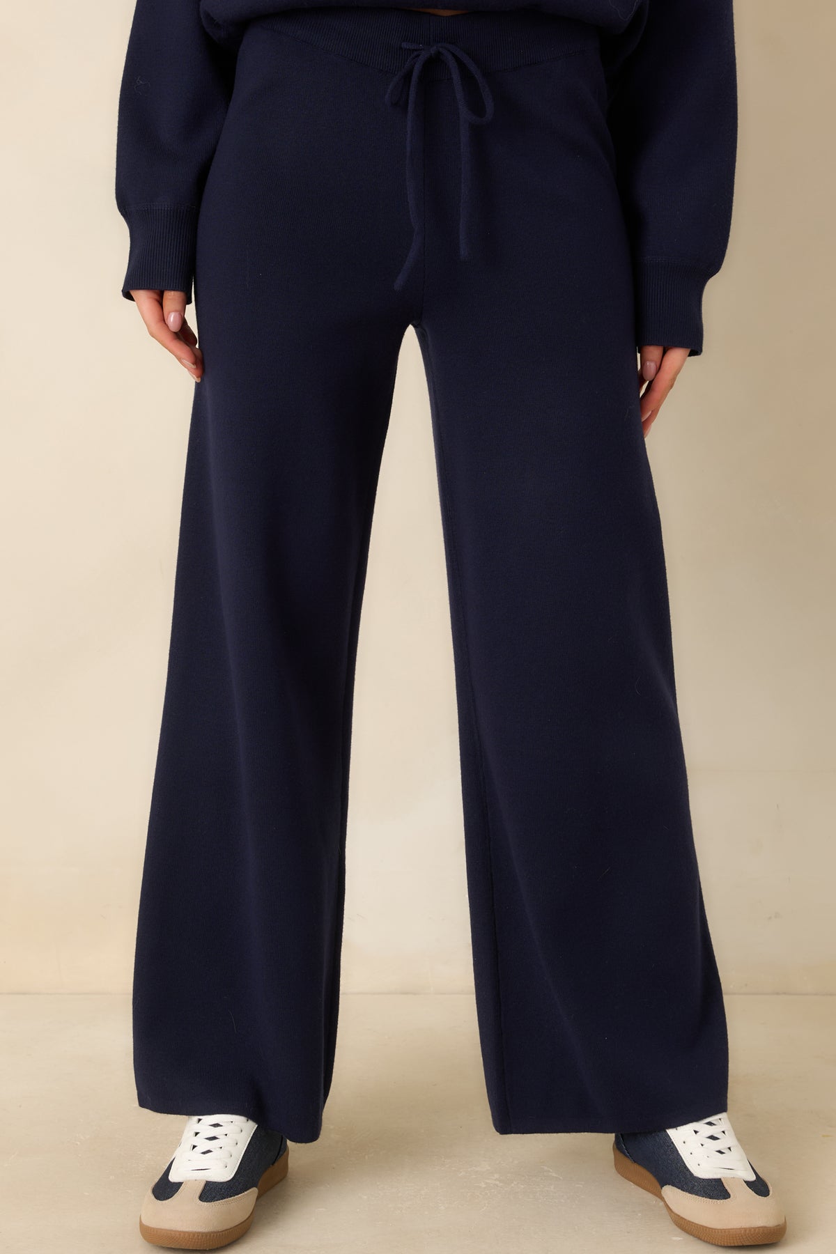 Soft sweater-knit fabric and relaxed wide-leg shape of the navy pants.