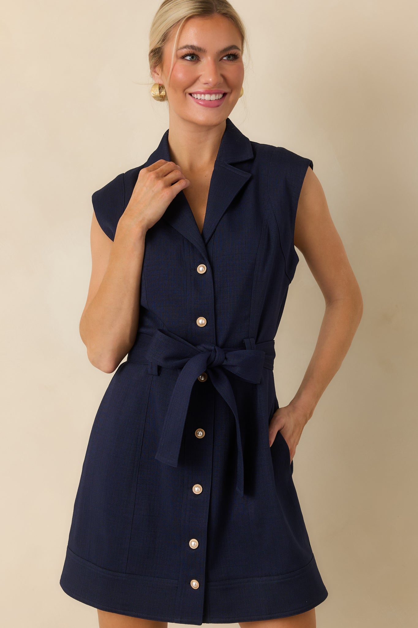Textured navy mini dress featuring princess seams, a removable self-tie belt, side pockets, and a wide banded hem.